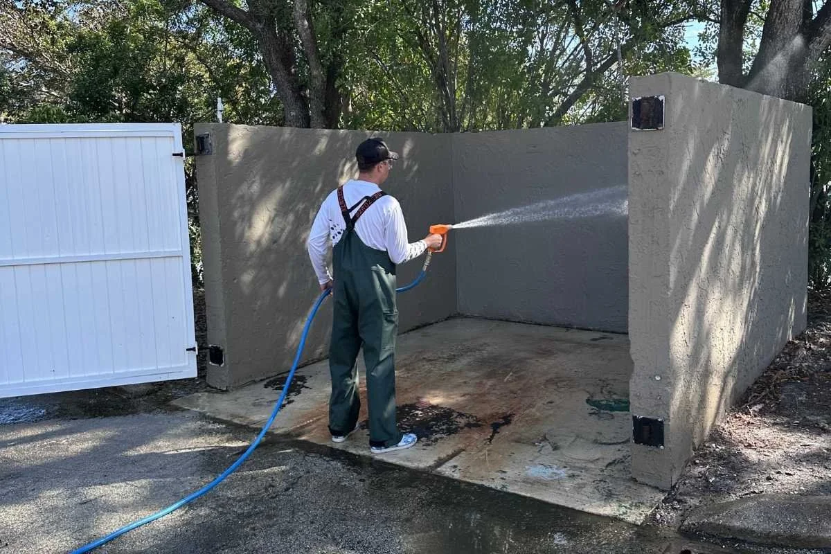 Dumpster area maintenance for a managed property with surrounding concrete and service access.