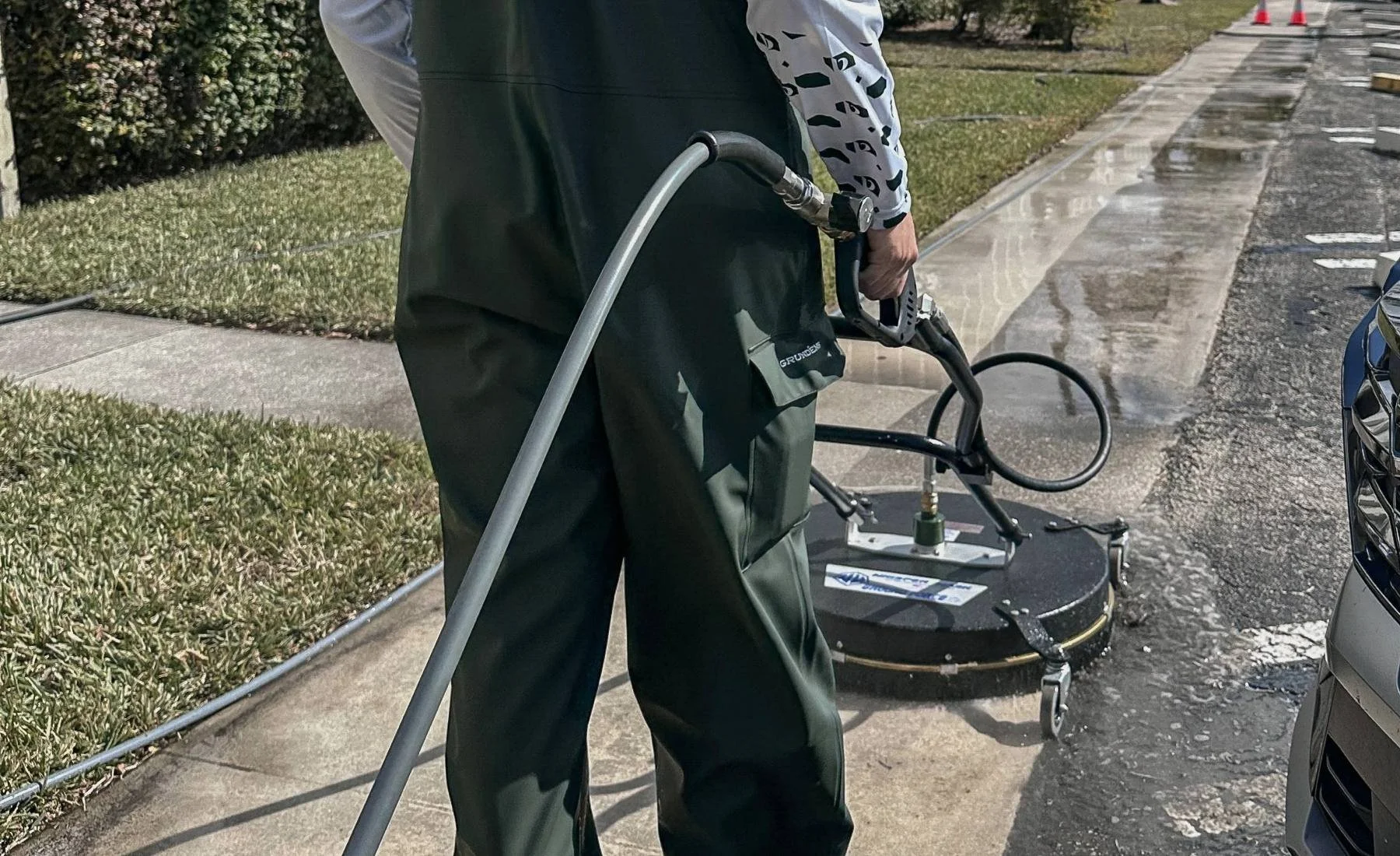 Professional exterior surface cleaning with surface cleaner on a sidewalk in Broward County.