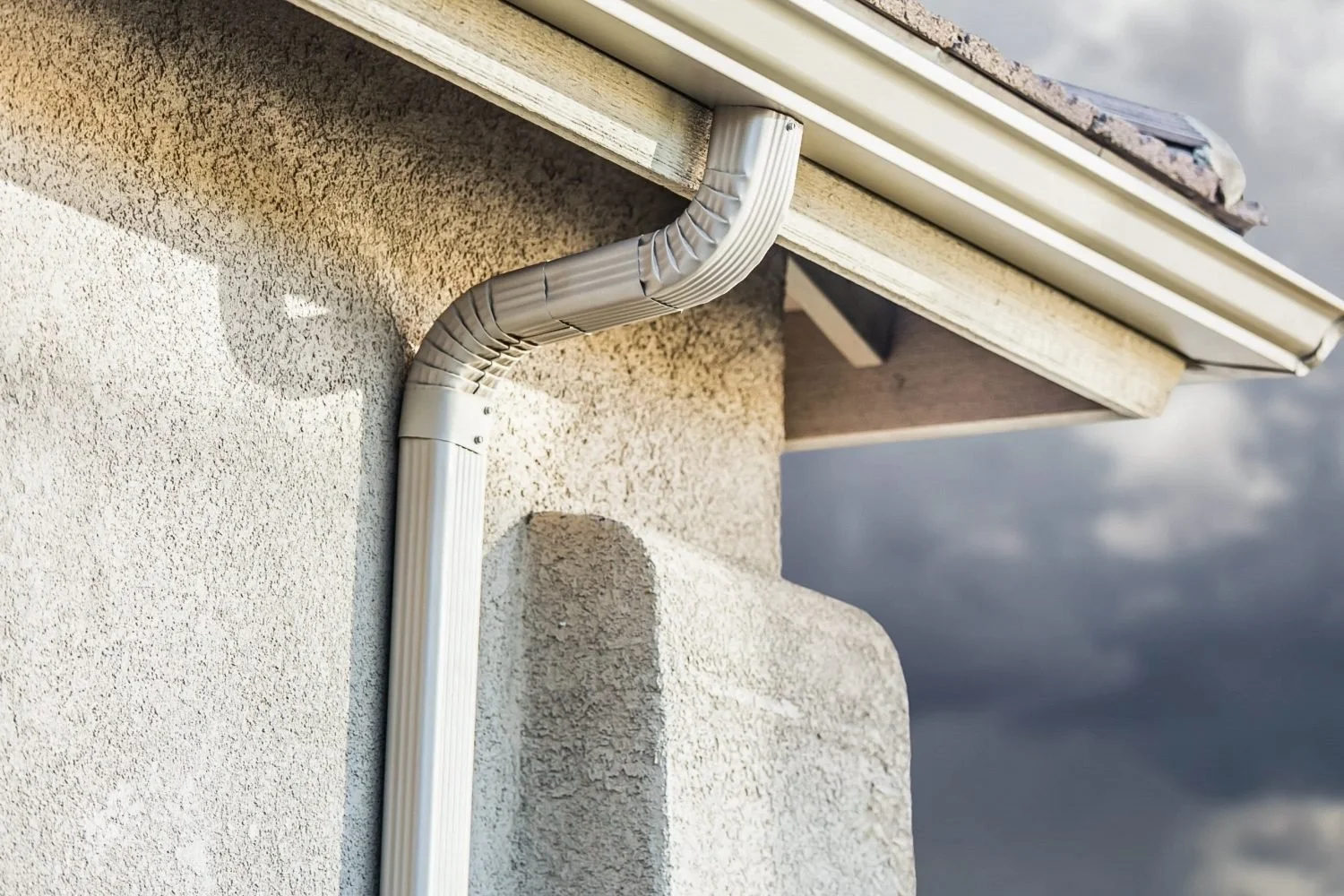 Stucco exterior wall, soffit, and gutter area exposed to moisture-related buildup in Broward County.