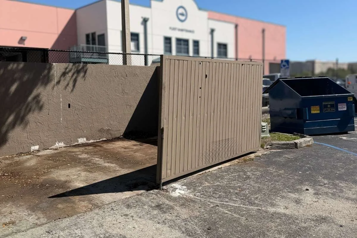 Dumpster pad concrete with grease and food residue buildup at a commercial property.