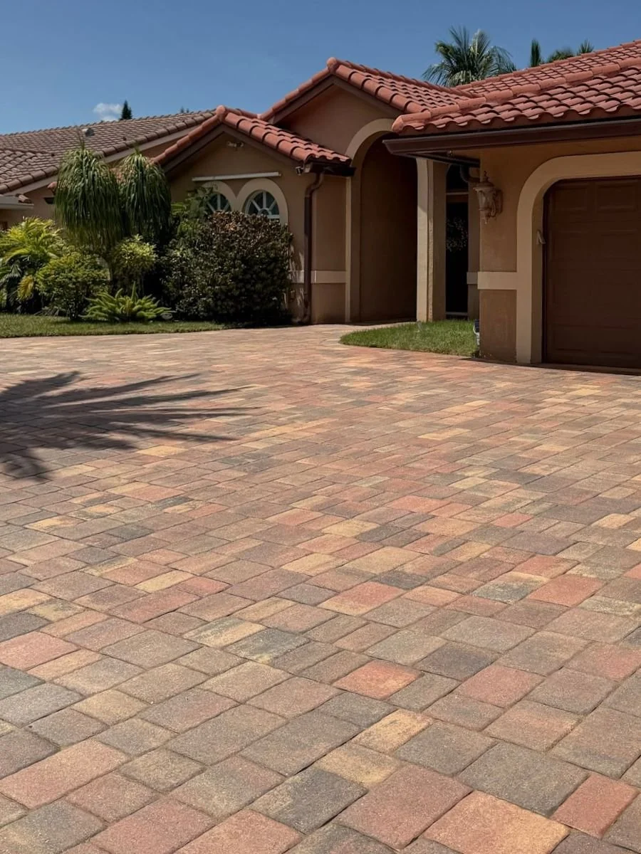 Brick paver driveway in Coral Springs after cleaning, joint re-sanding, and sealing, showing enhanced color and restored joints.