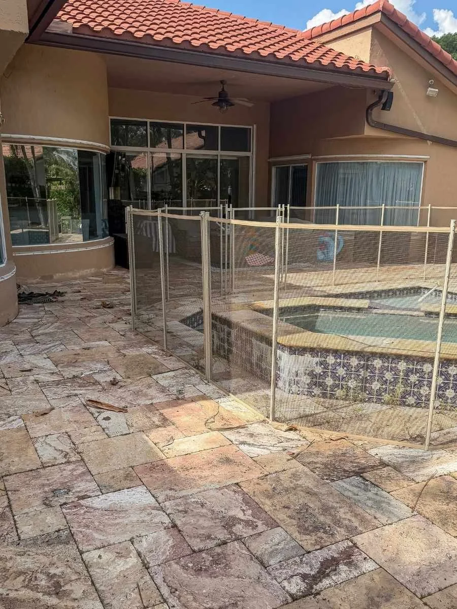 Travertine pool deck before cleaning and sealing, showing buildup, worn joints, and surface discoloration in Coral Springs.