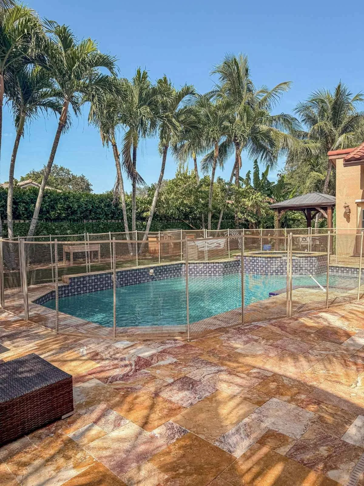 Finished travertine pool deck after cleaning and sealing at a residential property in Coral Springs, Florida.