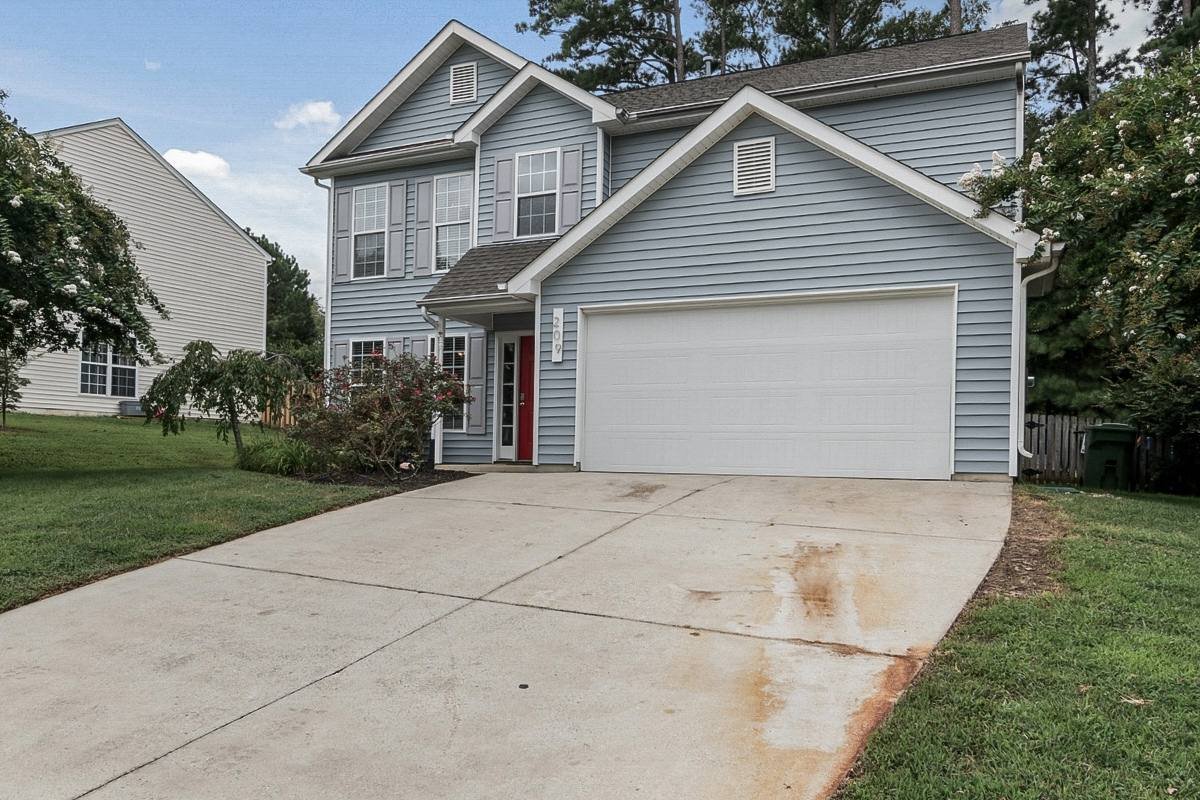 Rust and surface stains on a concrete driveway before professional driveway cleaning treatment.