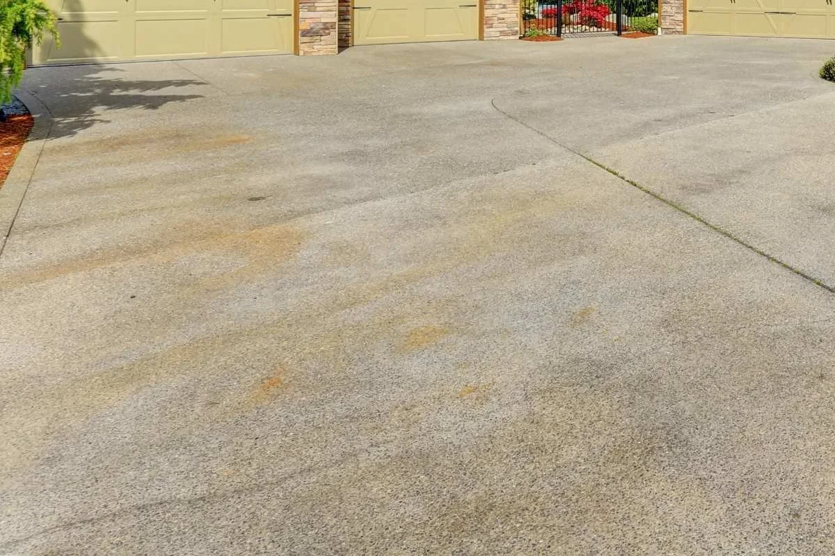 Concrete driveway in South Florida with visible stains from rain, vehicles, and organic buildup.
