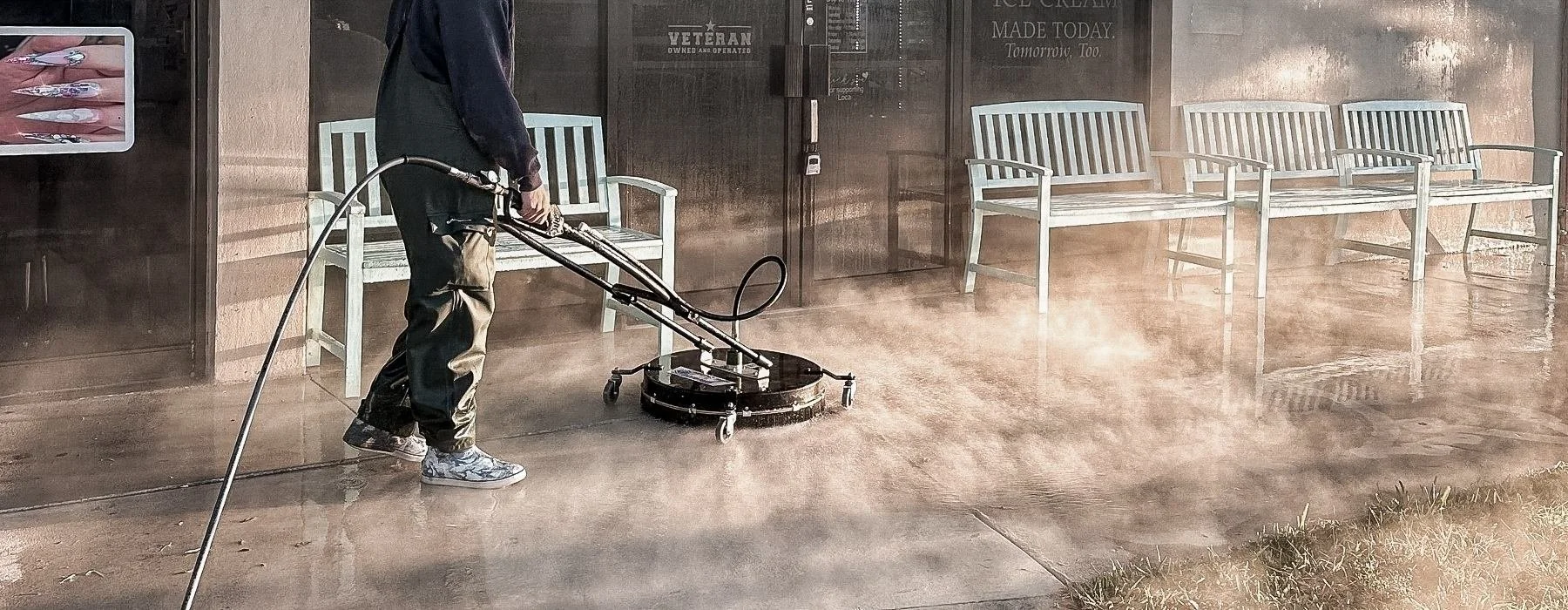 Professional commercial surface cleaning process using a surface cleaner on a storefront walkway in Broward County.