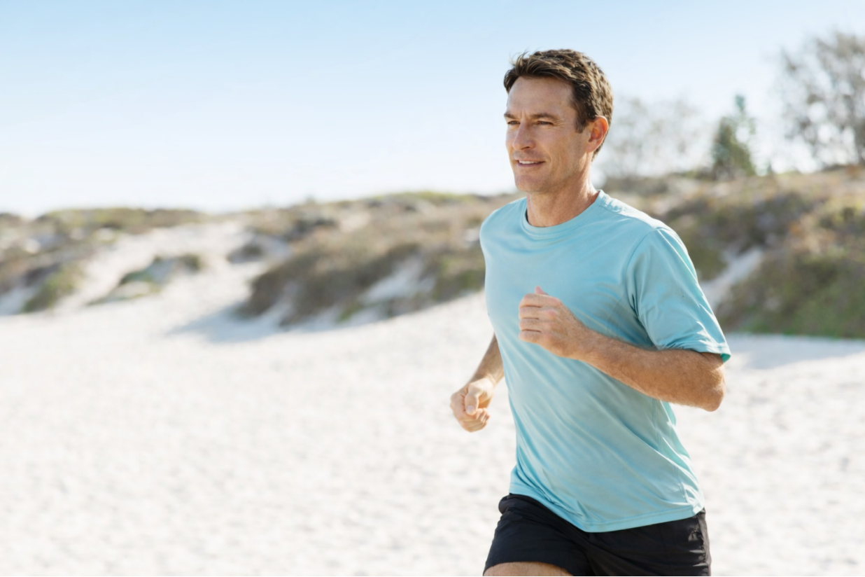 A man running outdoors on a sandy trail after advanced diagnostic testing and whole person healthcare in Austin TX at Westlake Medical Arts