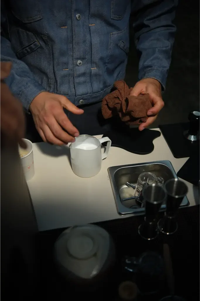 Eyevel barista crafting drinks behind the espresso bar