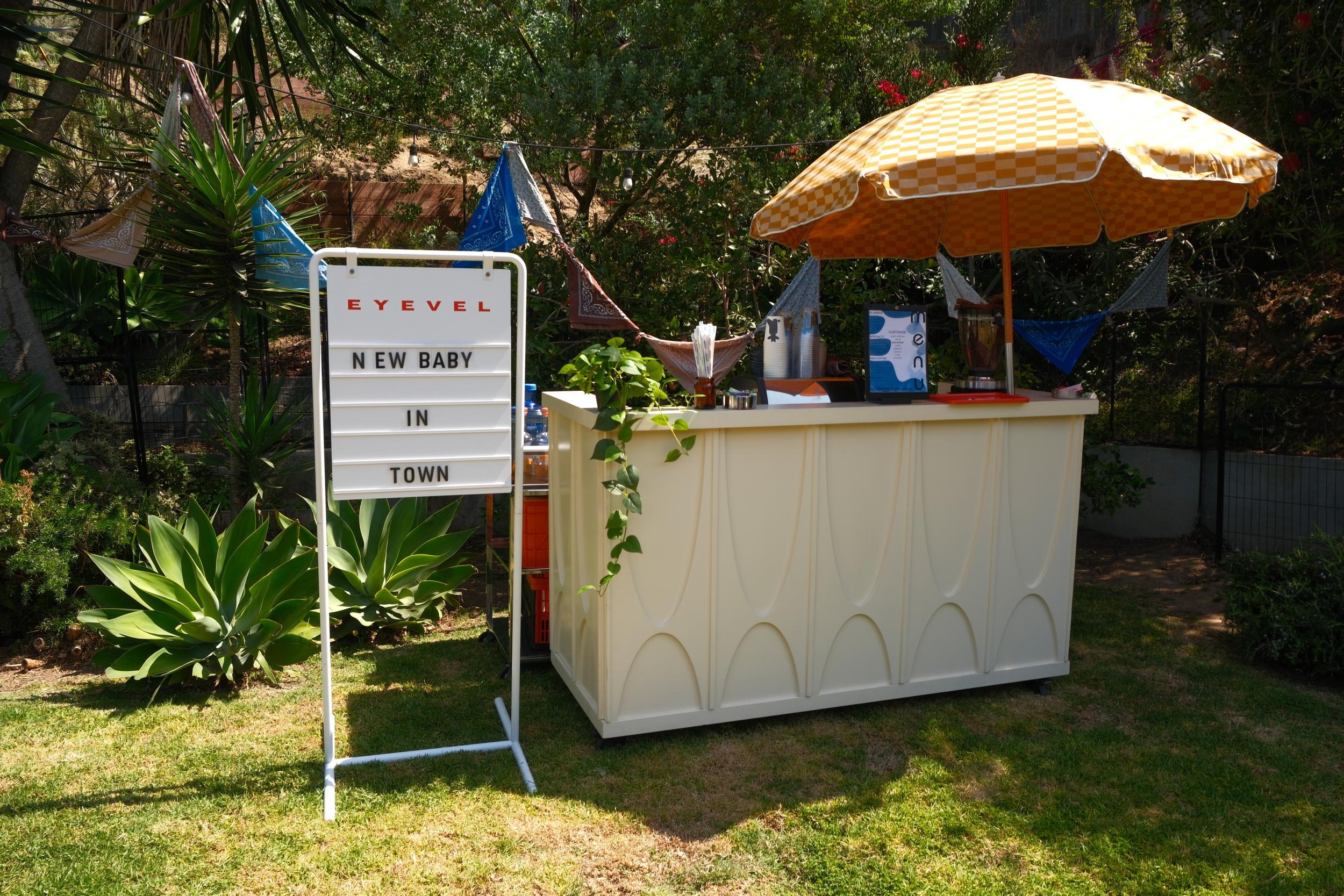 Eyevel coffee cart with a festival umbrella at a backyard celebration