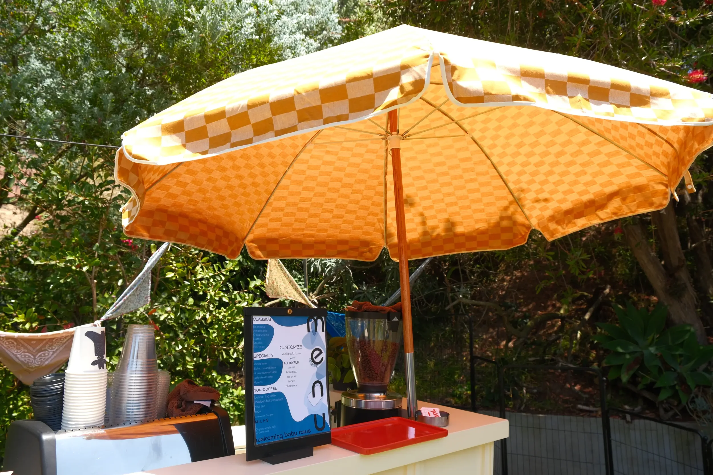 Checkered festival umbrella over the Eyevel coffee cart