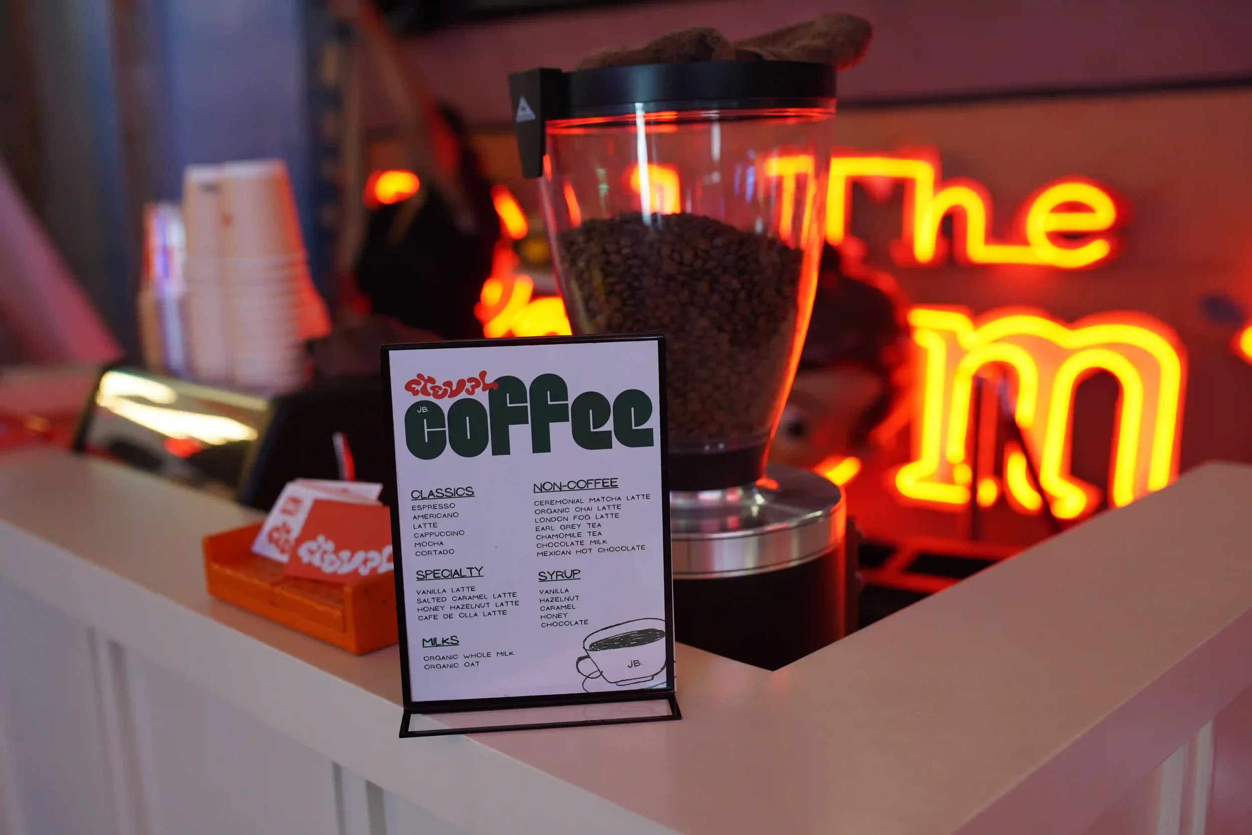 The event menu propped on the bar under a neon sign at a private party