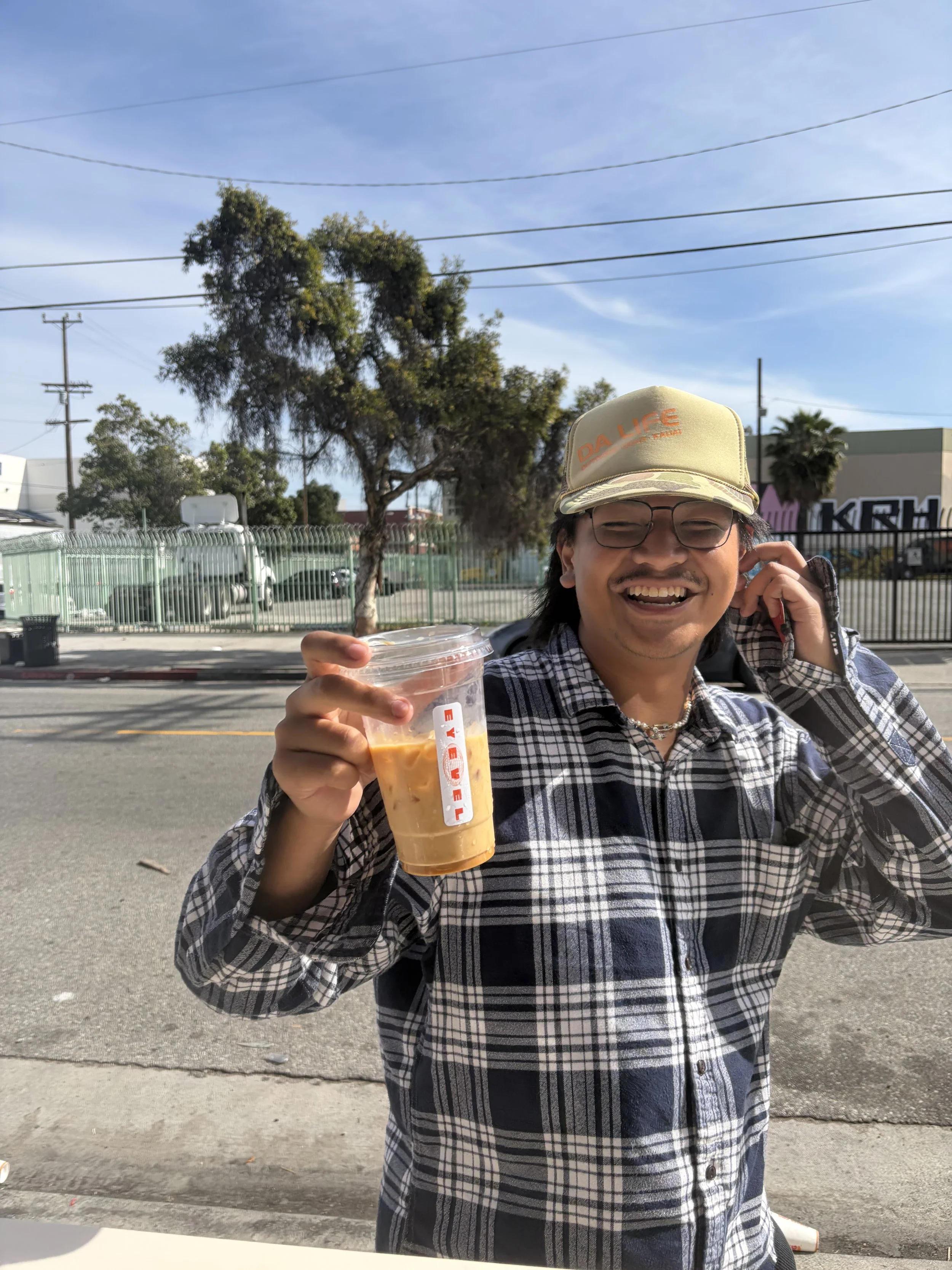 man smiling while holding cup with sticker branded eyevel 