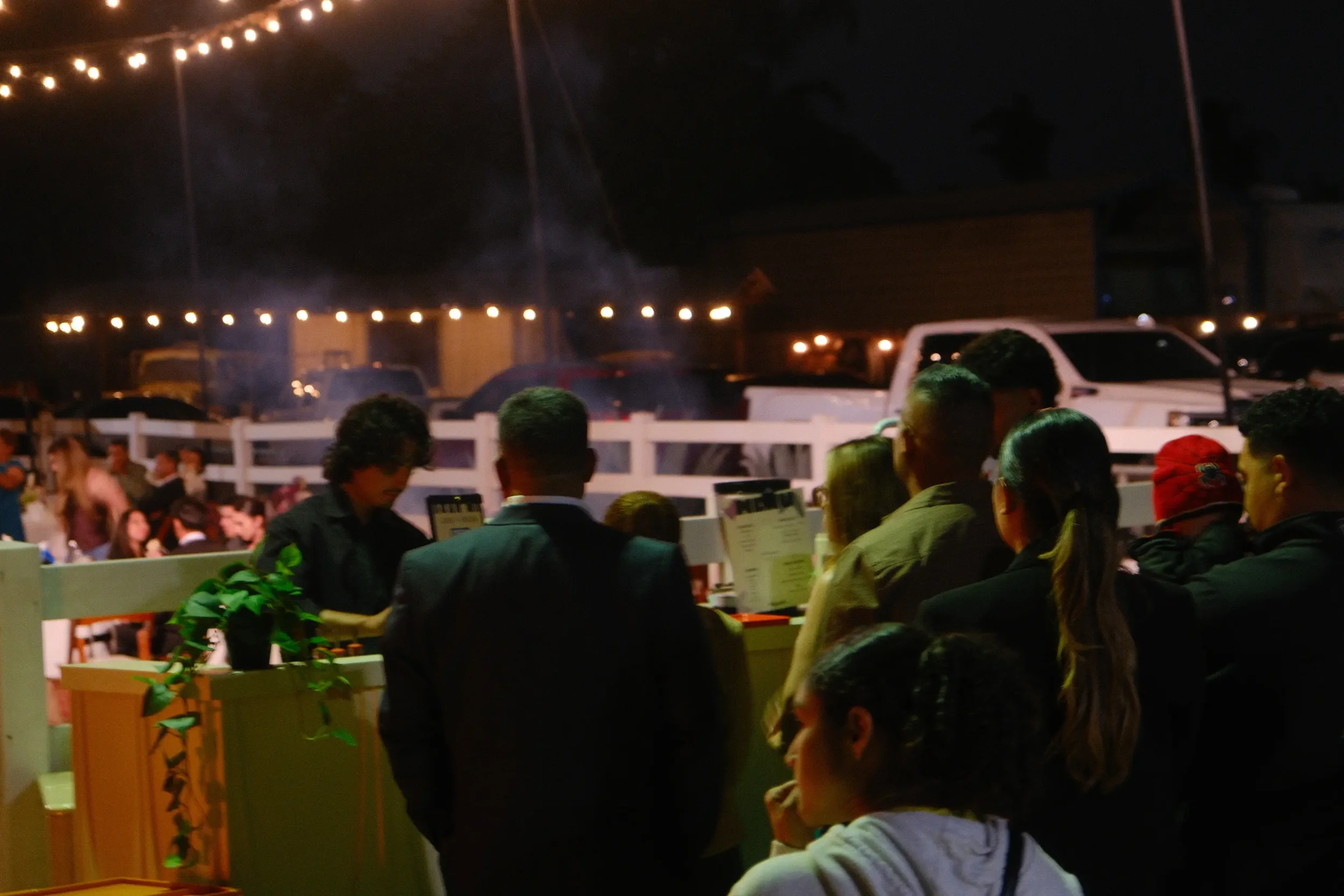 An evening crowd around the cart under string lights