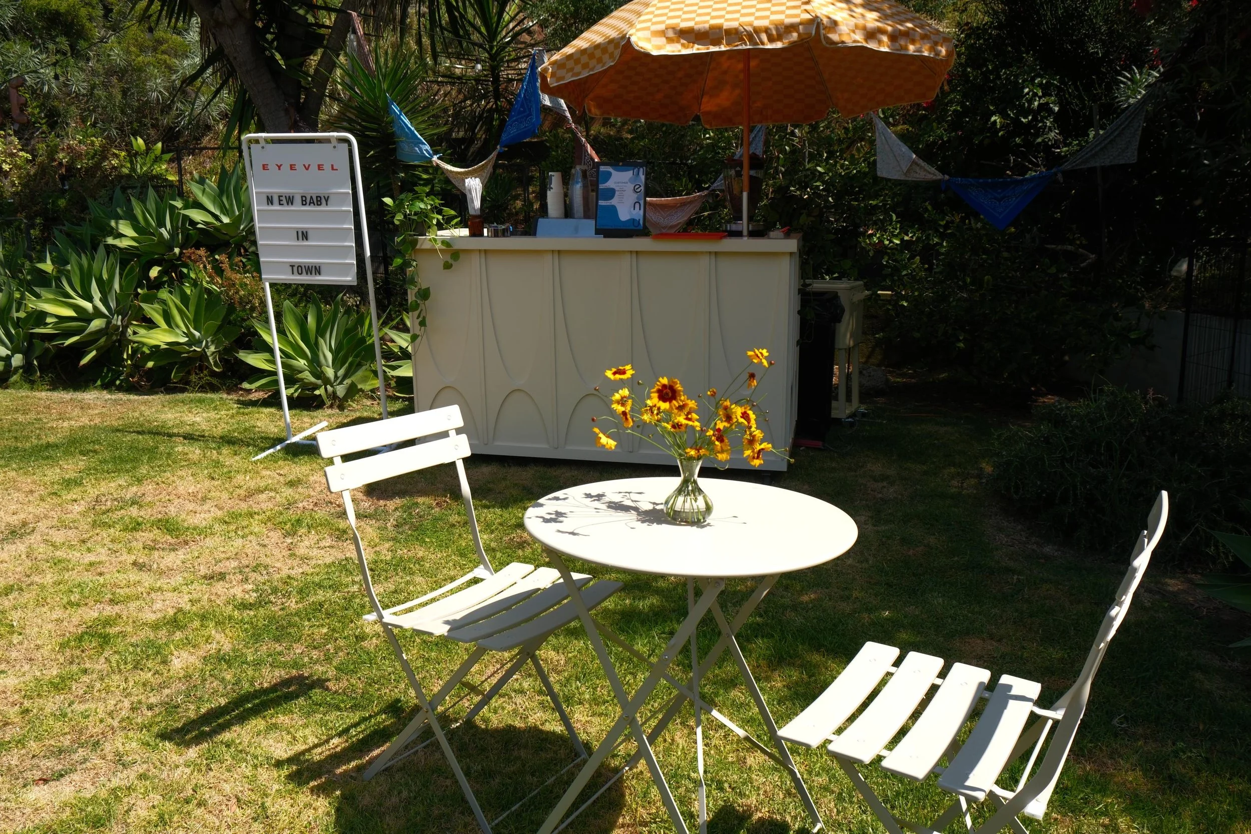 Backyard baby shower setup with bistro seating and the Eyevel cart