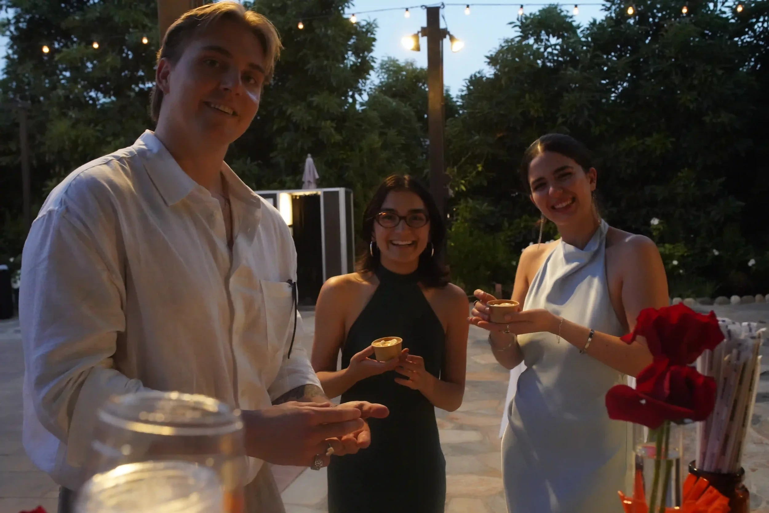 Guests smiling with their drinks at an evening event