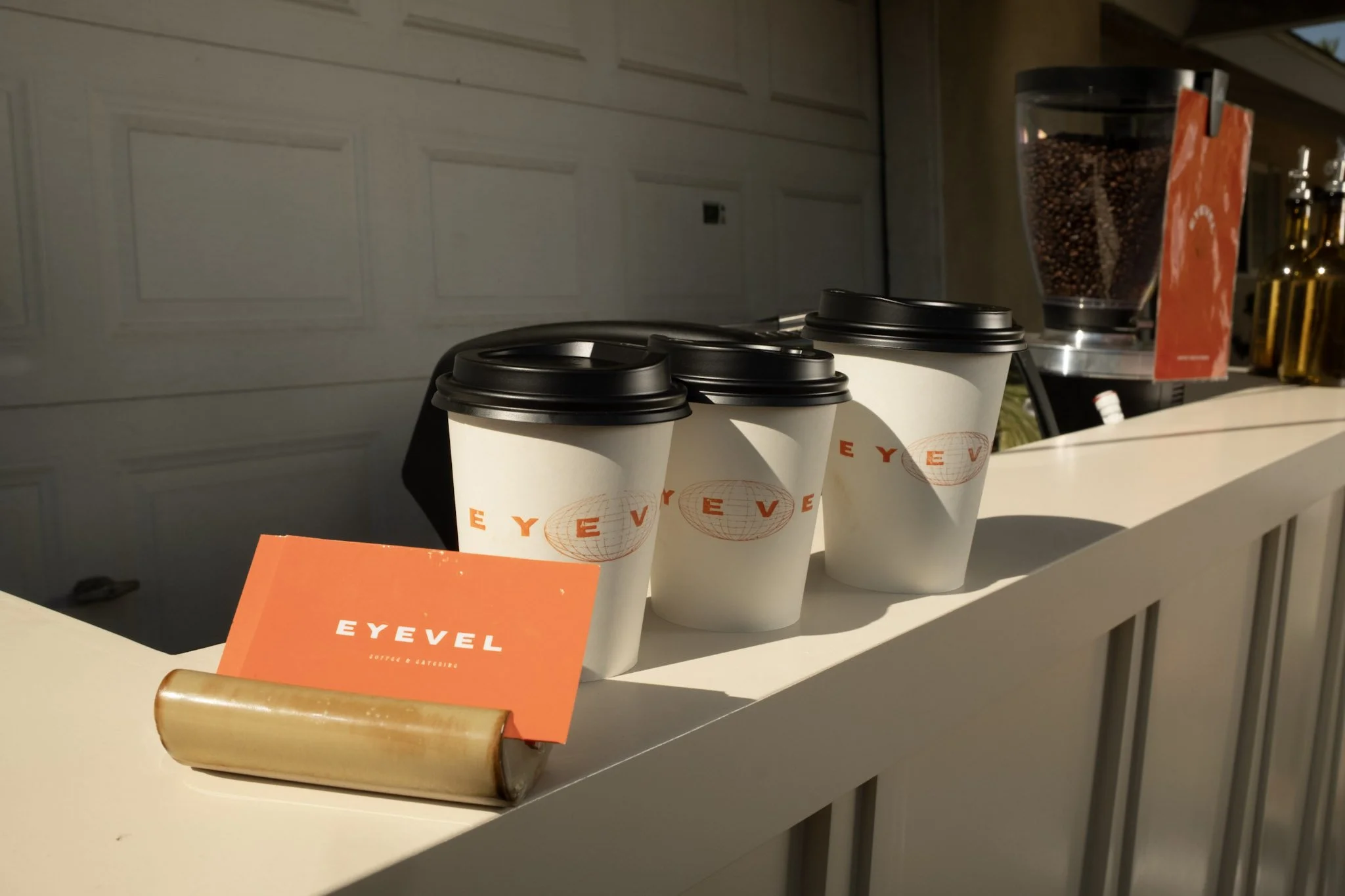 Custom branded cups and business cards saying EYEVEL