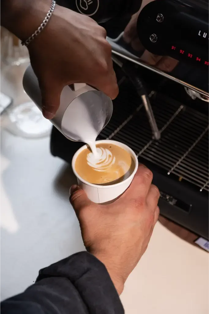 Eyevel barista crafting drinks behind the espresso bar