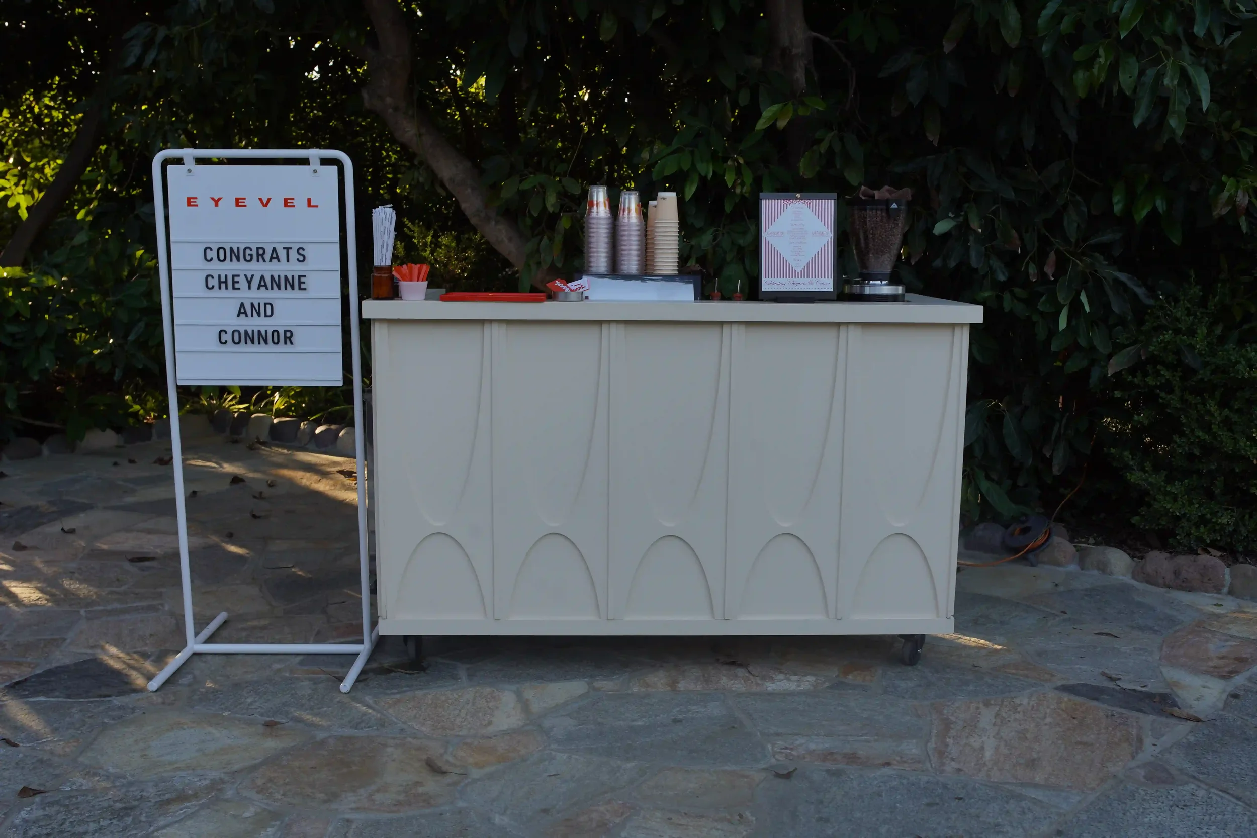 The Eyevel cart set up on a stone patio beside its letterboard sign