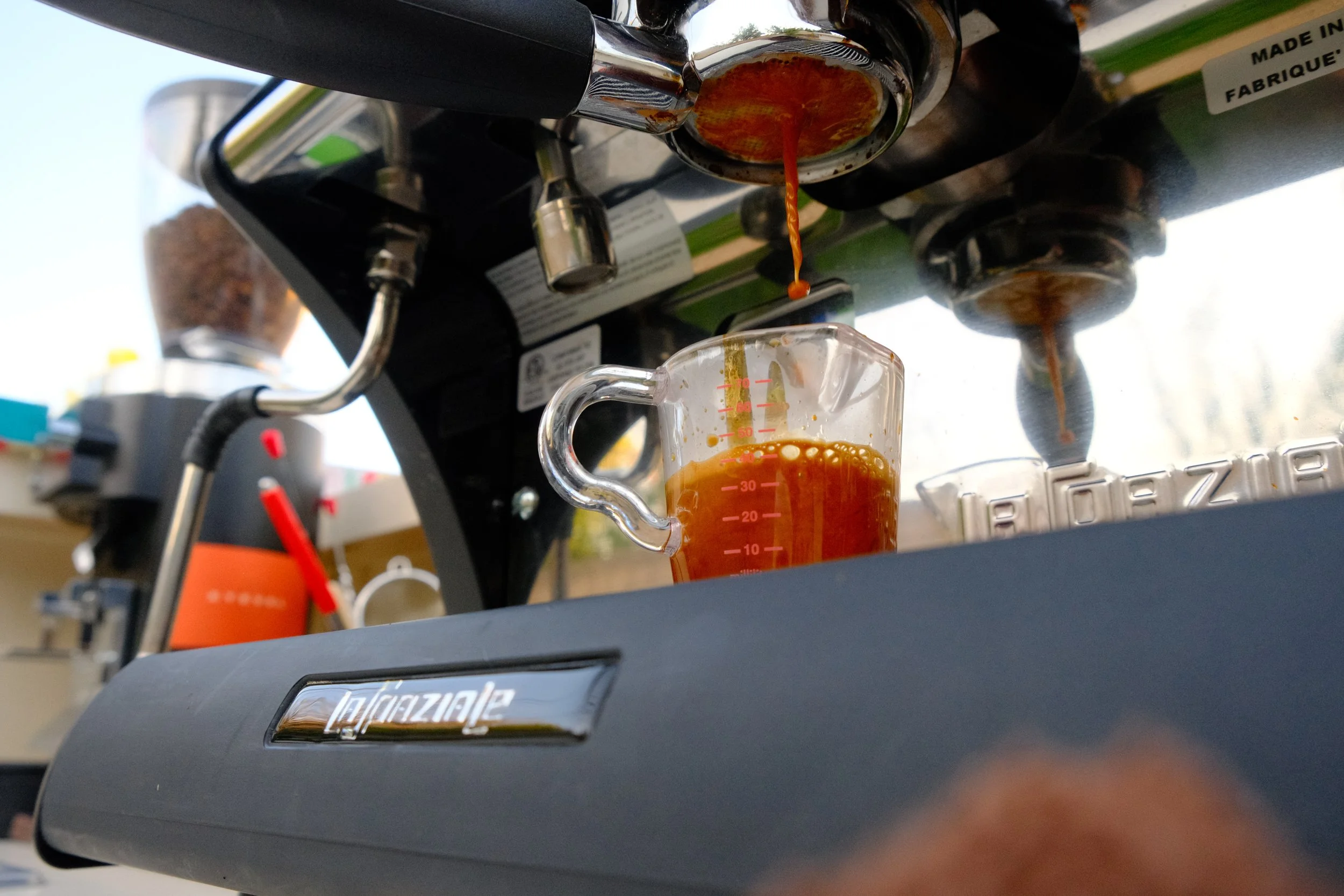 espresso machine pouring coffee into shot glass 