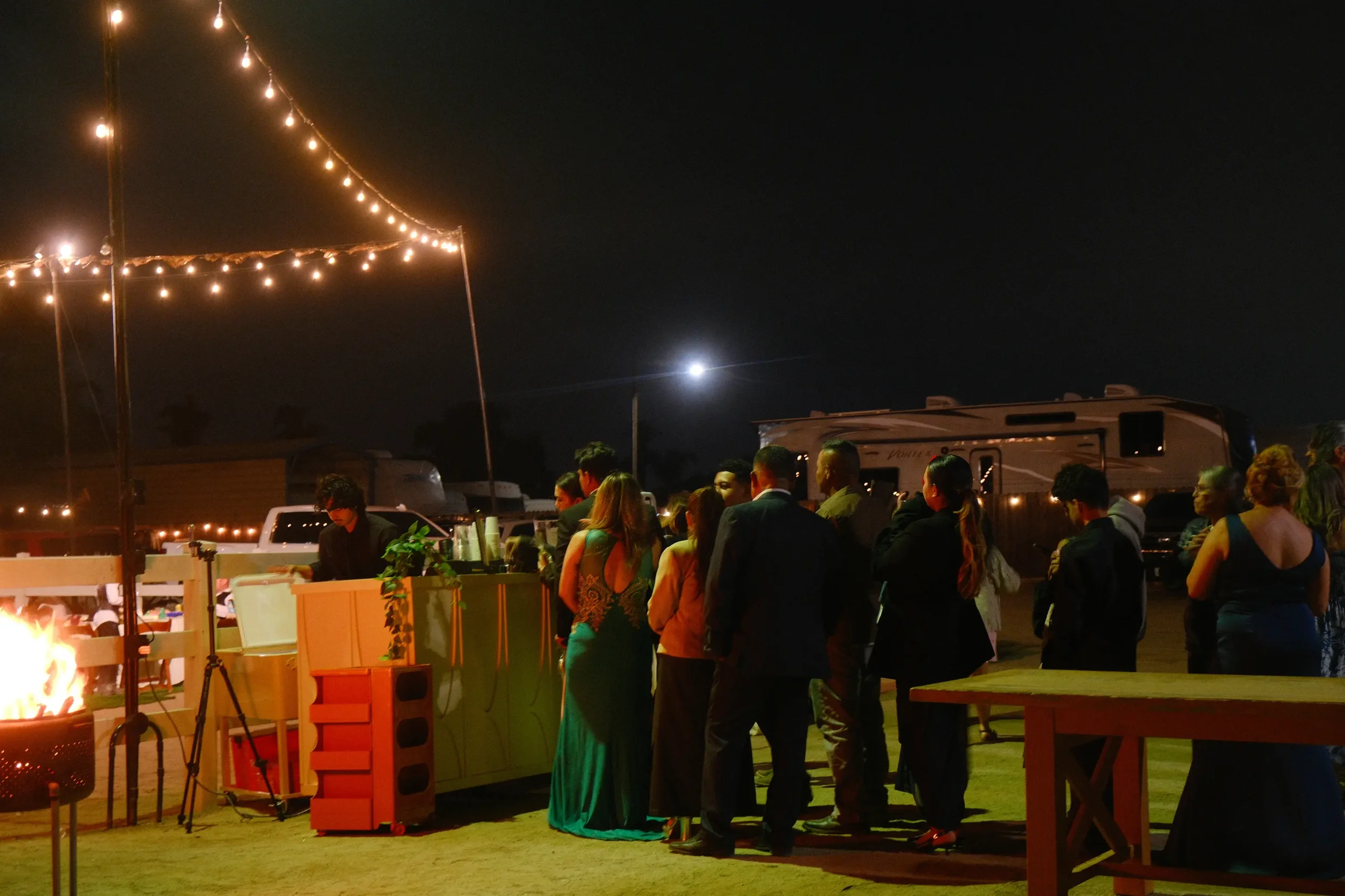 Party guests lining up at the Eyevel coffee bar under string lights