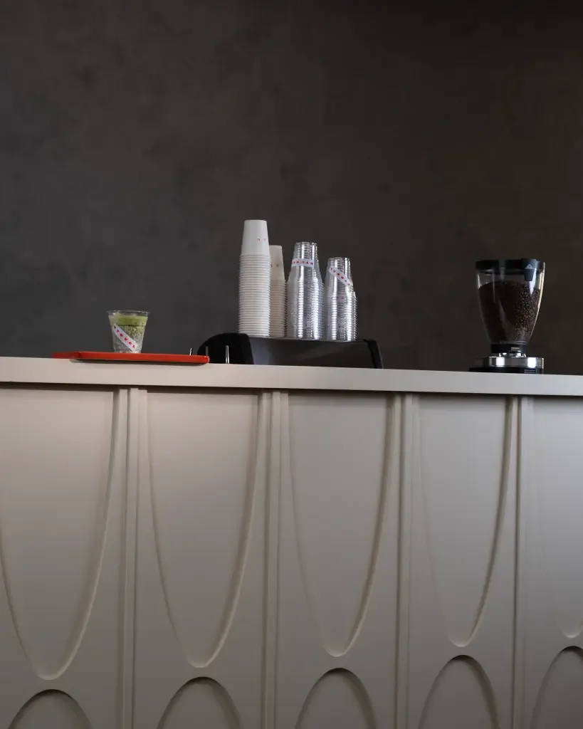 Sculpted arch paneling on the Eyevel cart, grinder and cups staged
