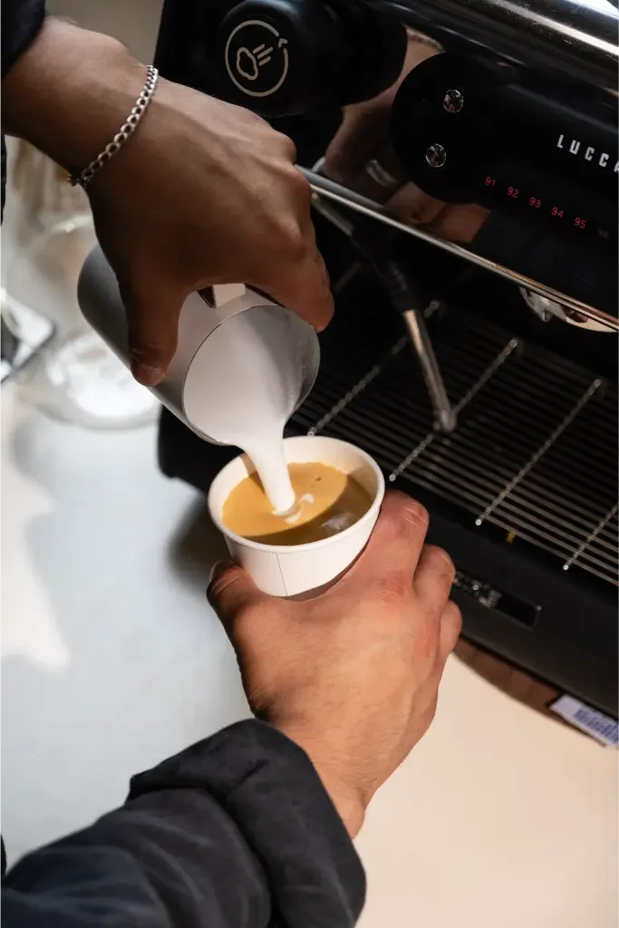 Eyevel barista crafting drinks behind the espresso bar