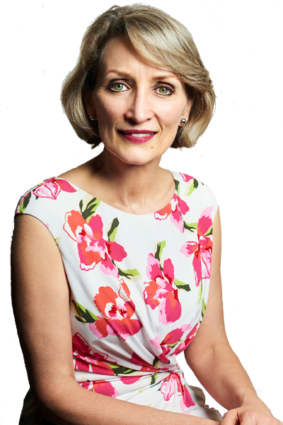 A woman with short blonde hair wearing a white dress with pink and red flower pattern.