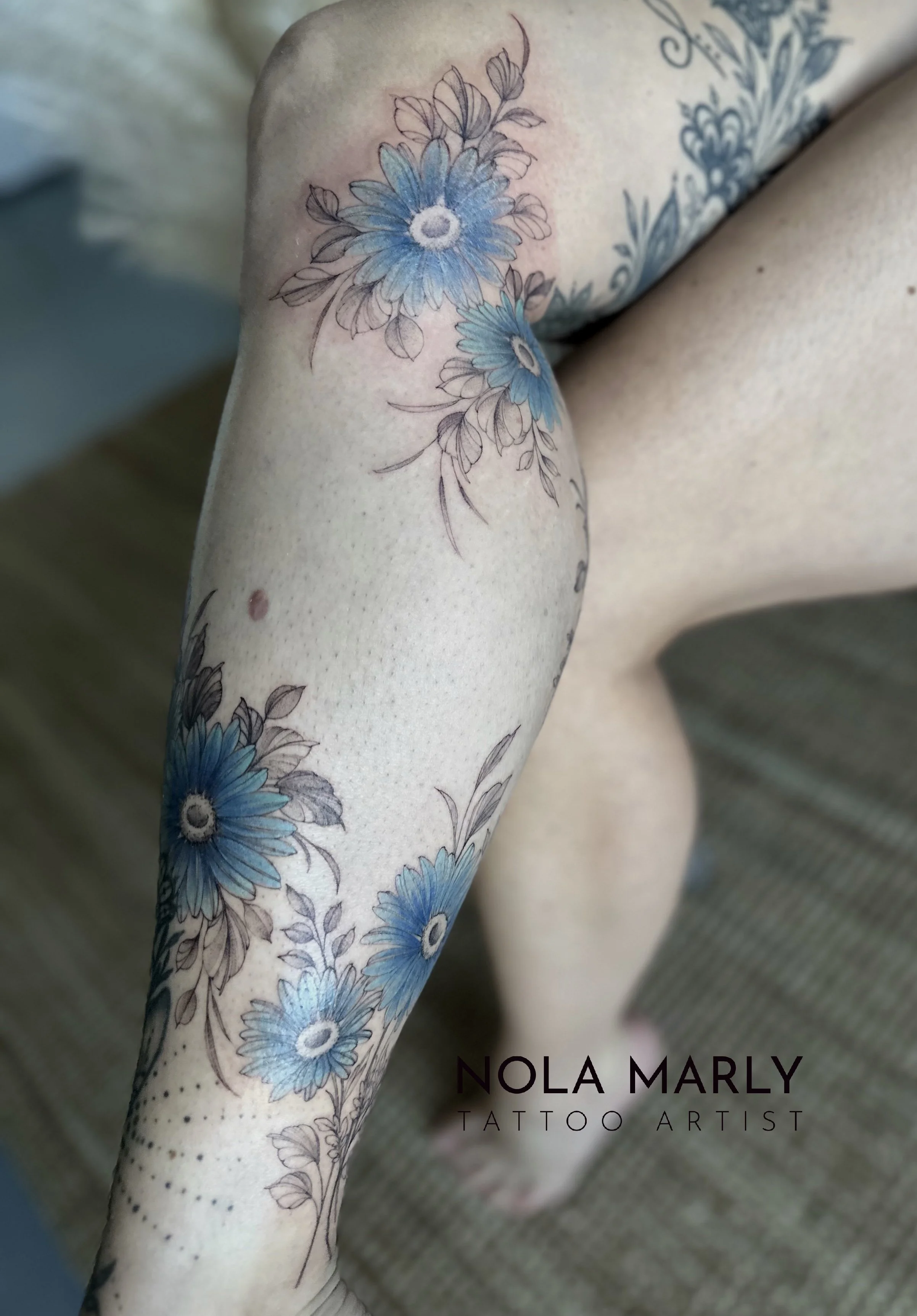 Tattoo Demi-jambe Marguerite bleu fineline féminin et détaillé 