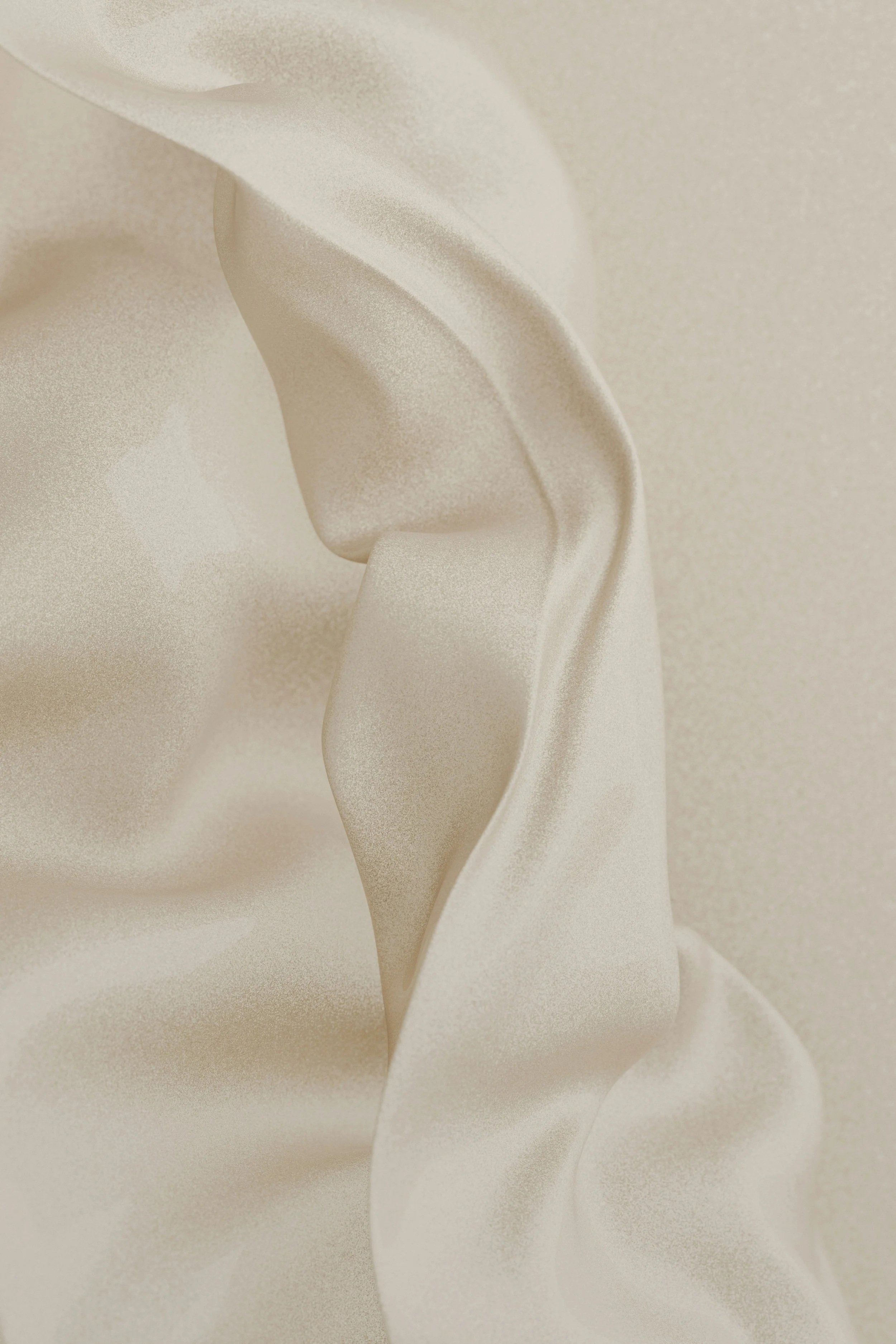 Close-up of smooth, ivory-colored satin silk fabric with soft folds and a slight sheen.