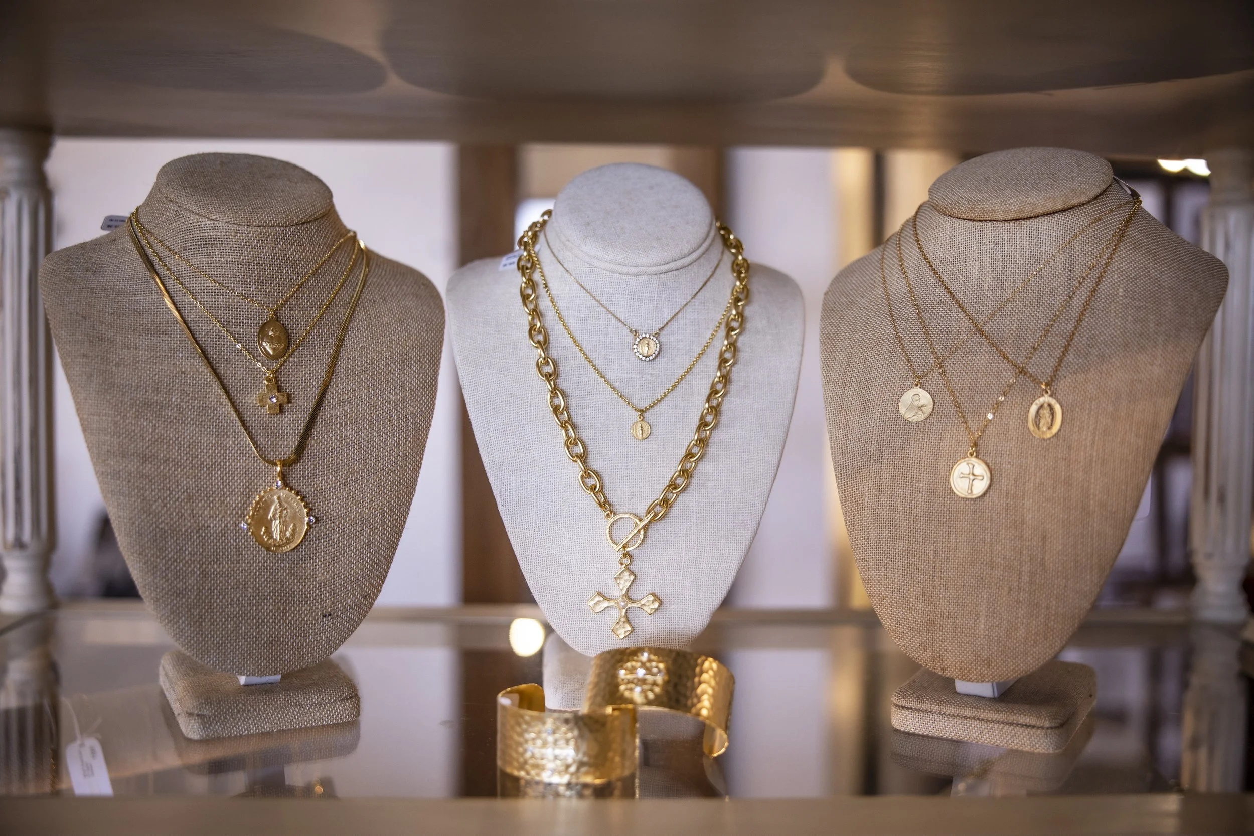 Gold jewelry on three mannequins