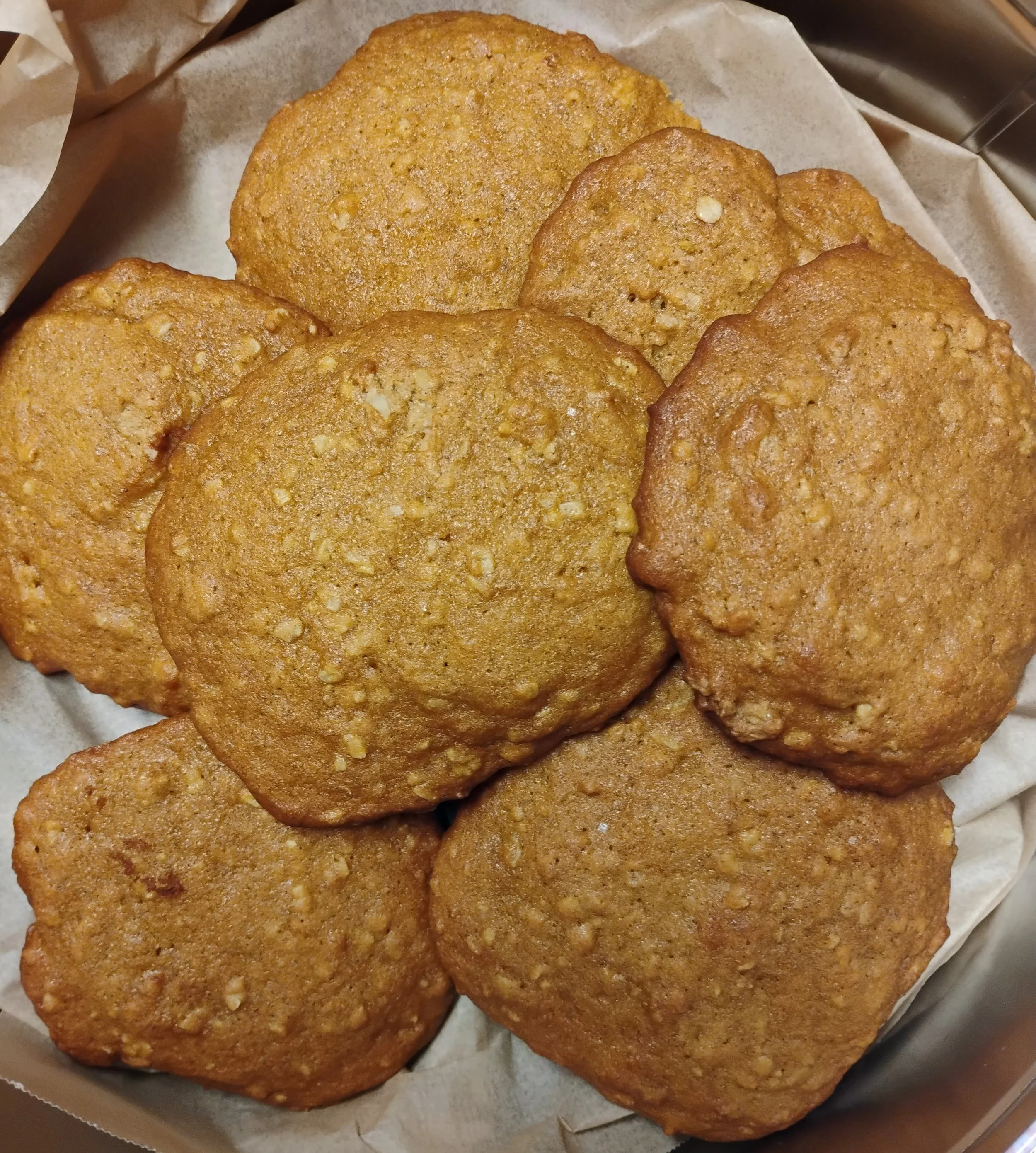 A group of six pumpkin cookies on parchment paper