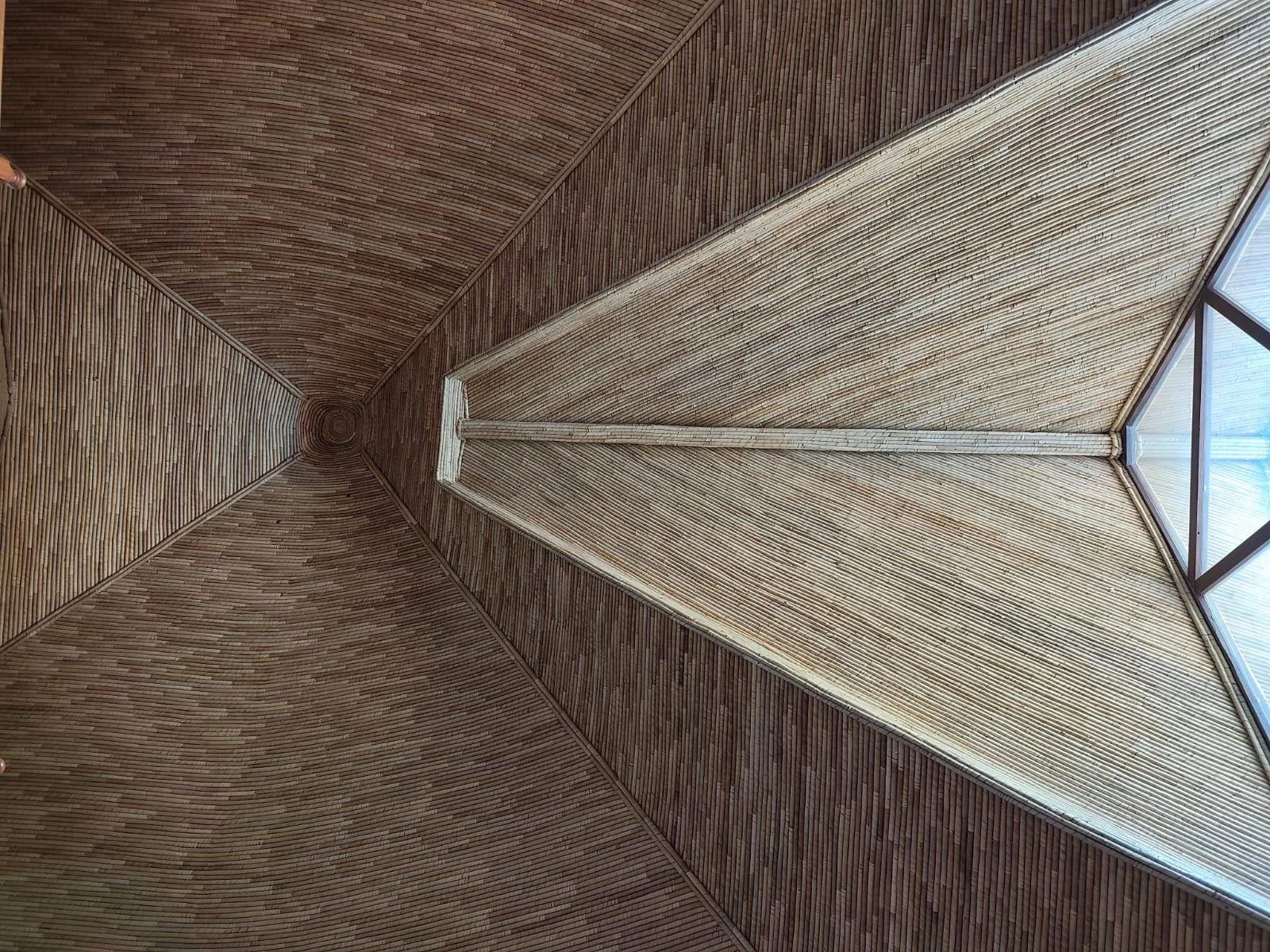 Intérieur d'une structure en bois en forme de pyramide avec fenêtre en verre