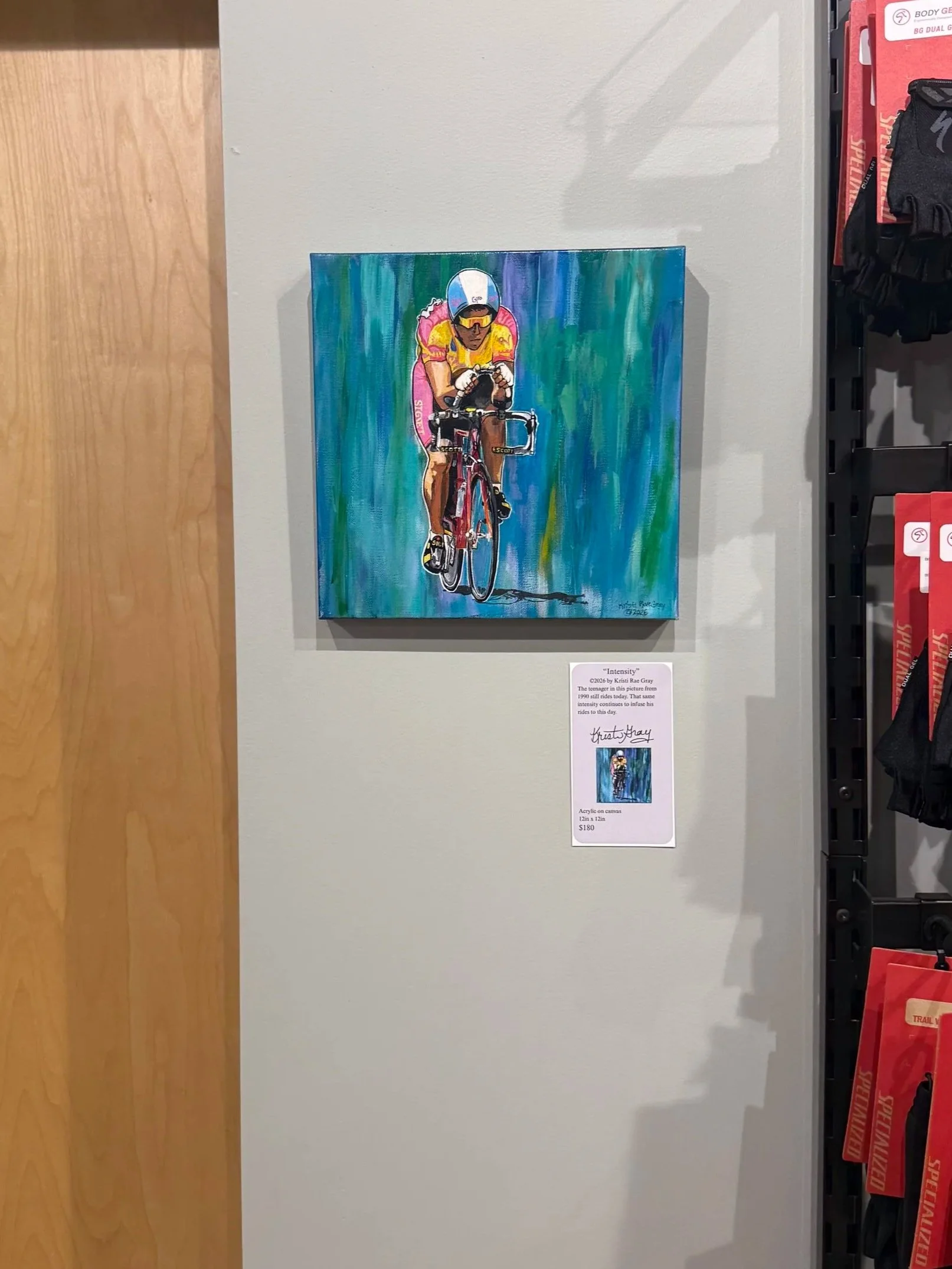 Intensity is a 12 in by 12 inch acrylic painting of a single racing cyclist in about 1989 or 1990. It’s hanging on the wall next to a product display in Cardinal Bicycle in Grandin Village in Roanoke Virginia.