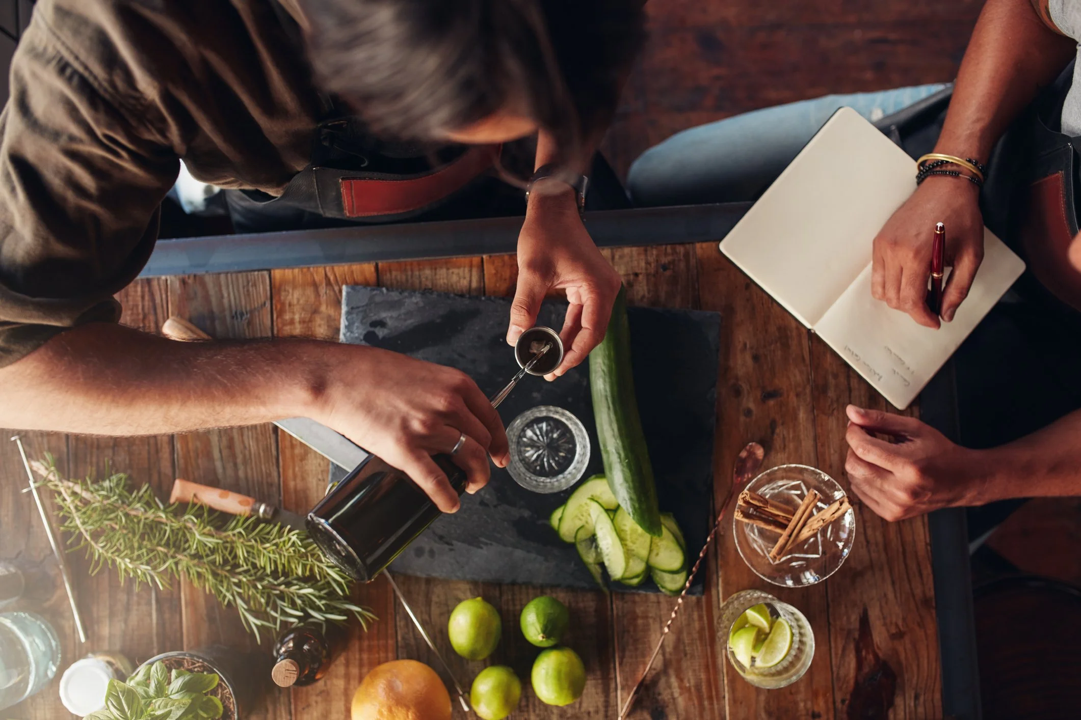 Two people learning how to mix craft cocktails.