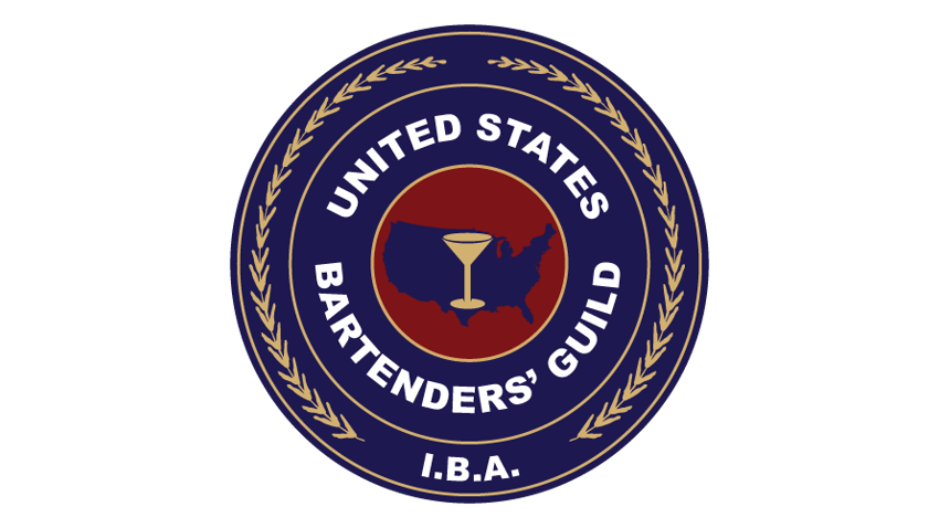 The emblem of the United States Bartenders' Guild with a navy blue circular border, gold laurel leaves, and a central design featuring a red map of the United States with a cocktail glass. The text reads 'United States Bartenders' Guild' and 'I.B.A.'