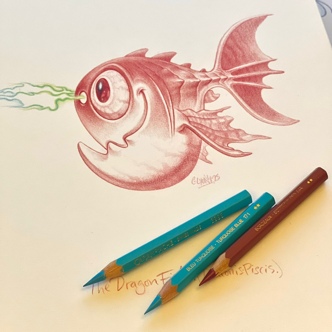 A drawing of a fish with a large eye and a big smile, shooting out green and blue laser beams from its nose. The fish has fins and a tail, and the drawing is done in reddish tones. Two colored pencils, one red and one blue, are lying near the drawing with handwritten notes underneath.