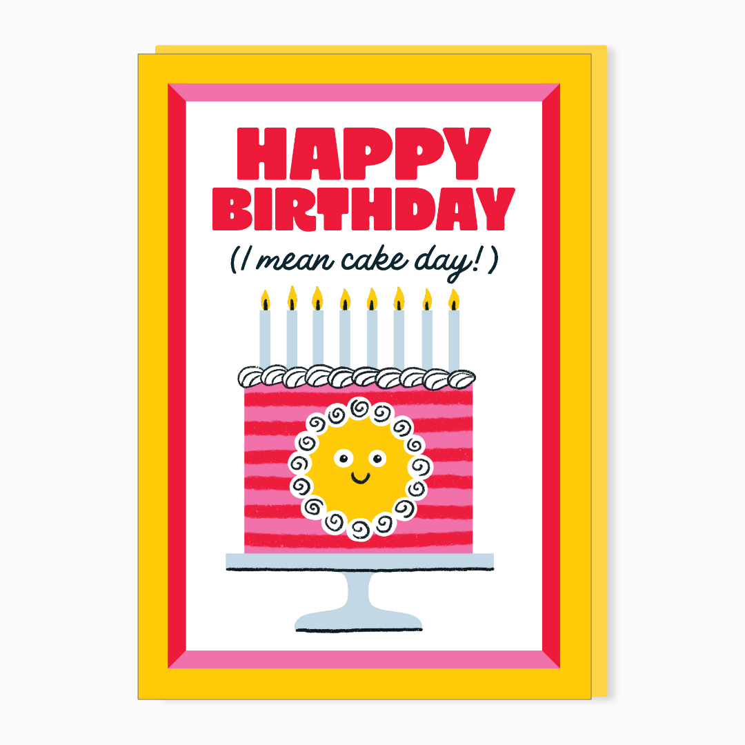 A colorful birthday card with a pink and yellow border. The card has the text "HAPPY BIRTHDAY" in bold red letters, with "(I mean cake day!)" written below in black. There is an illustration of a birthday cake with pink stripes, white icing, and a smiling yellow face in the center, topped with seven lit candles.
