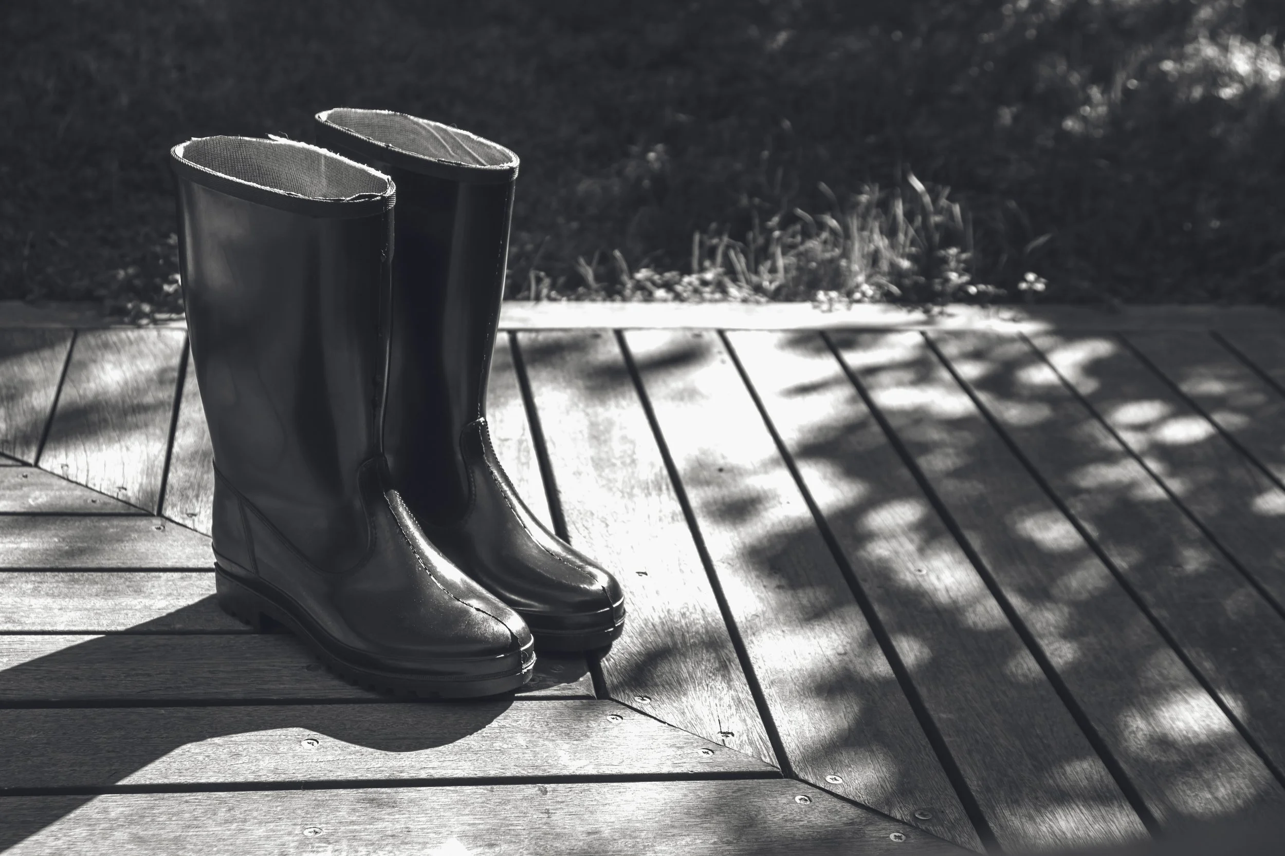 grayscale-shot-boots-wooden-surface.jpg