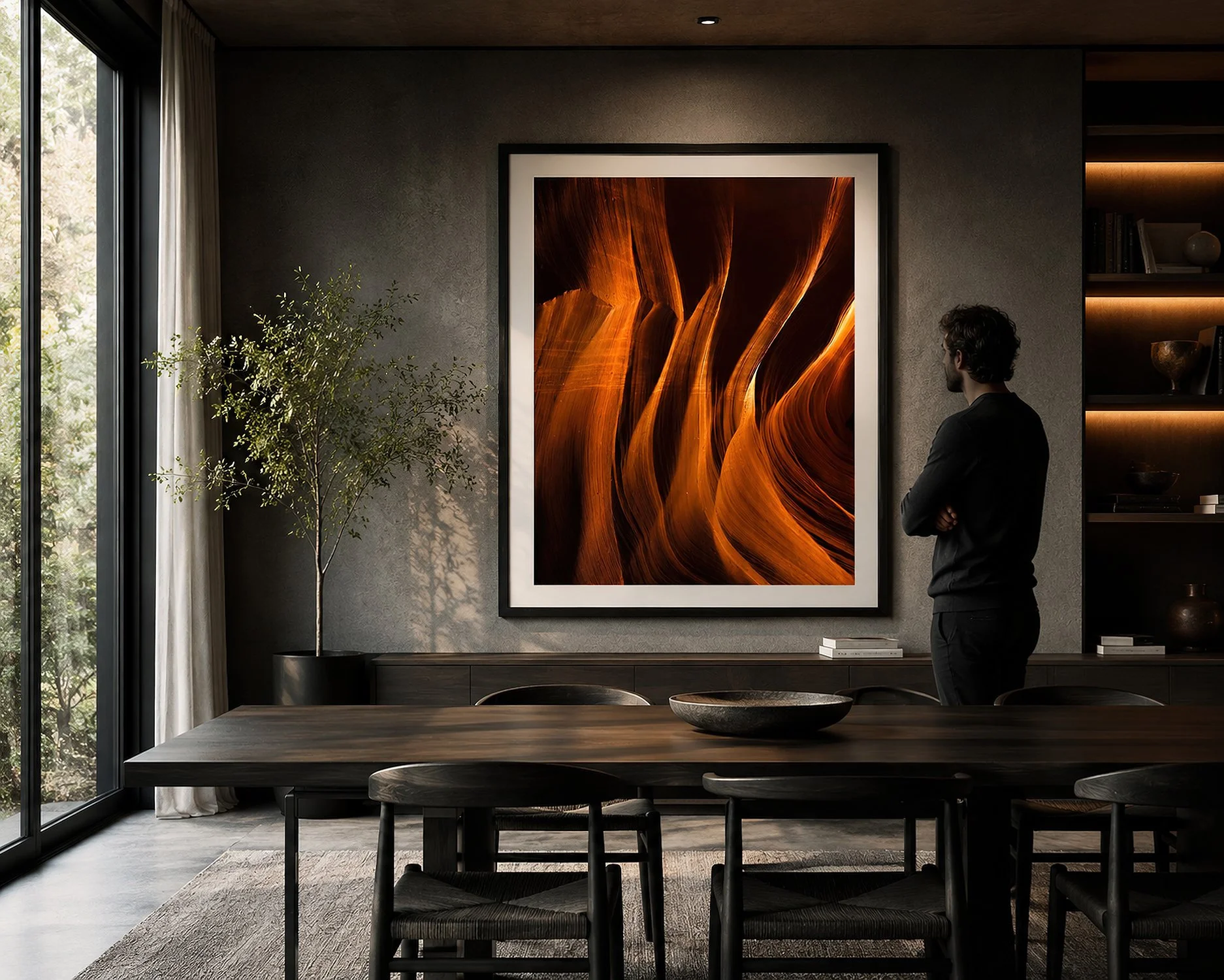 Framed Antelope Canyon photograph displayed in a dark modern dining room with a man standing nearby.