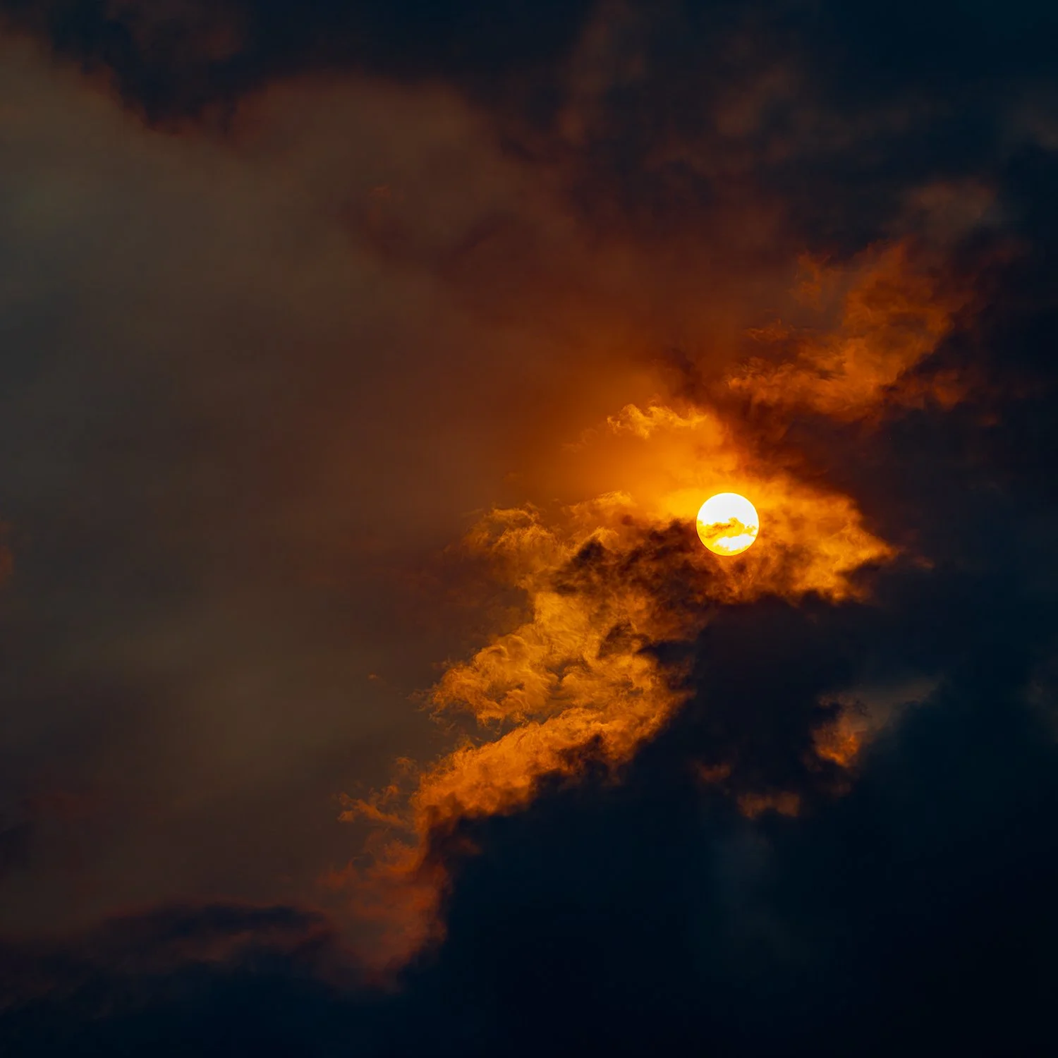 Dramatic golden sky fine art photograph with dark clouds and atmospheric light