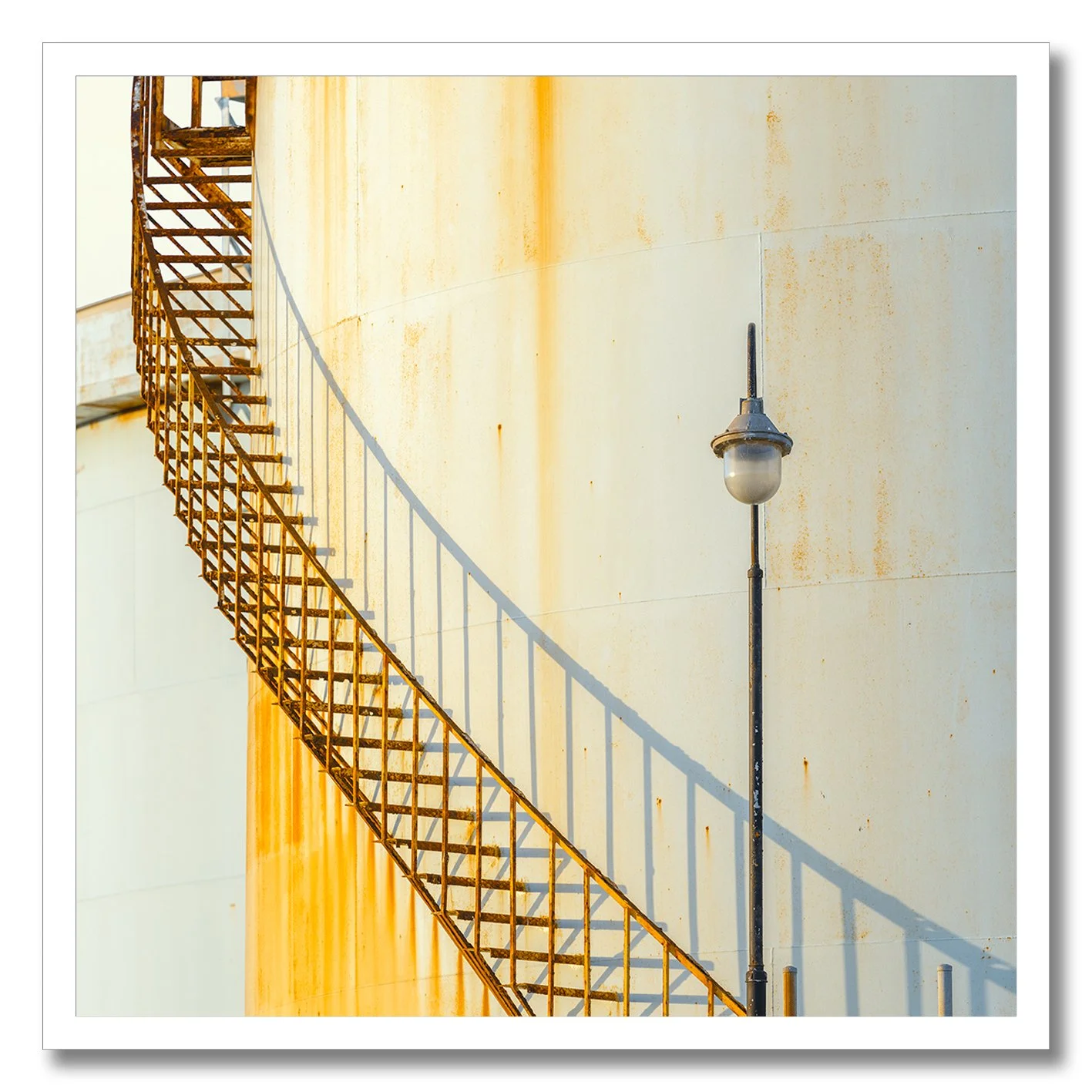 industrial staircase and lamp against rusted wall photograph