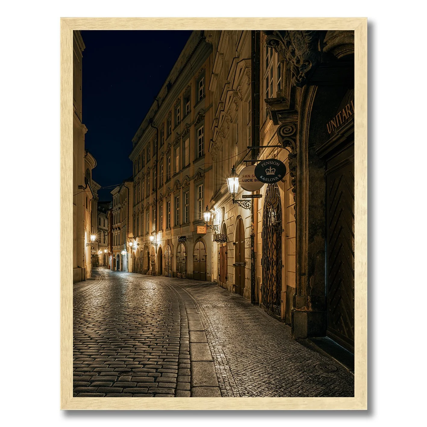 Night photograph of a quiet cobblestone street in Prague with warm lamps