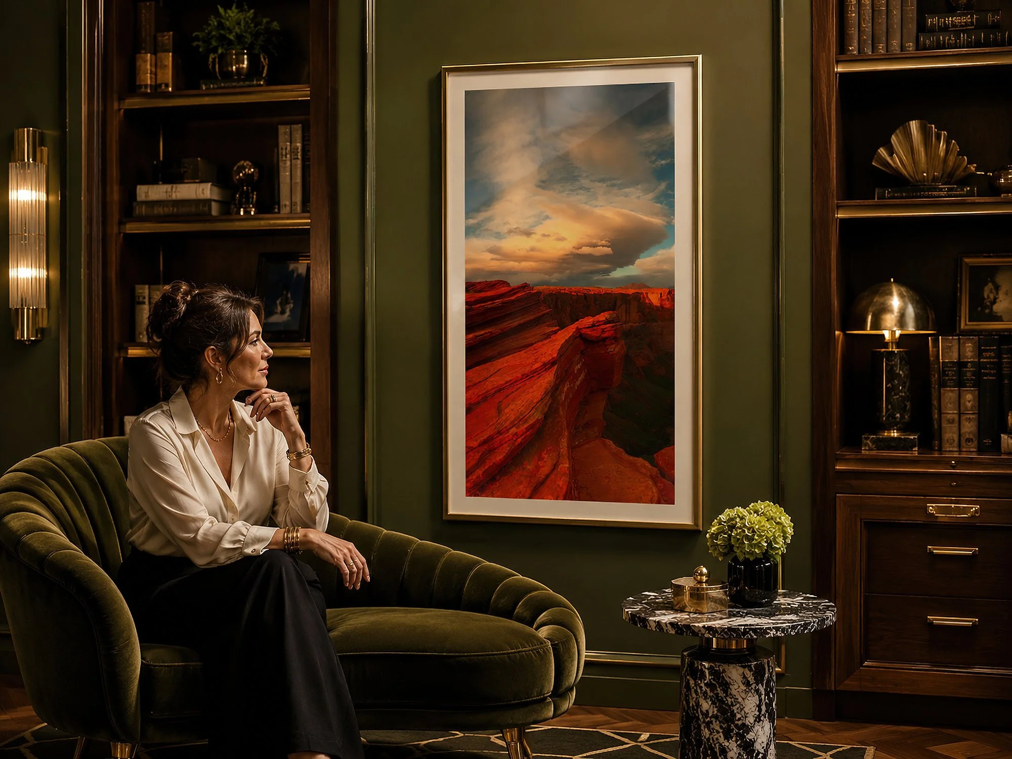 Framed Arizona canyon photograph displayed in an elegant green library lounge with a seated woman.