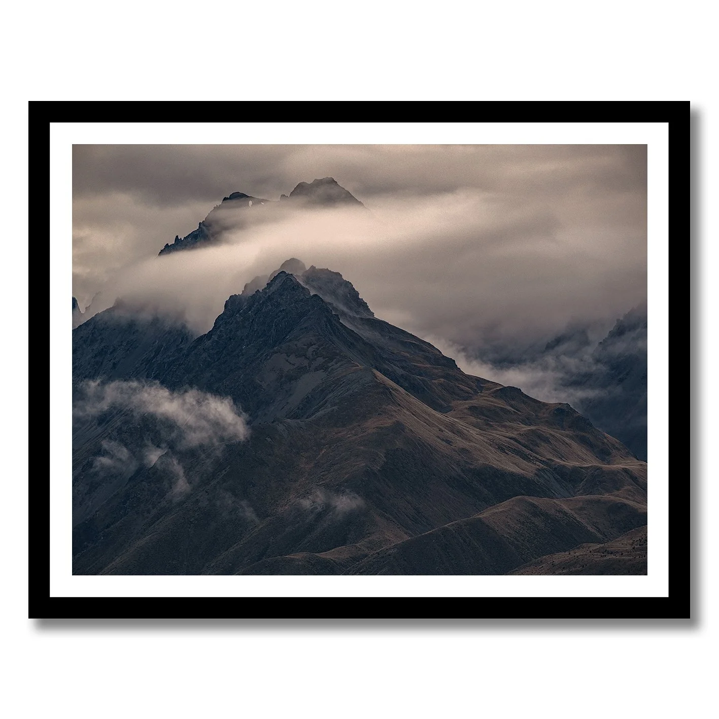 Moody mountain photograph with mist drifting across dark alpine ridges