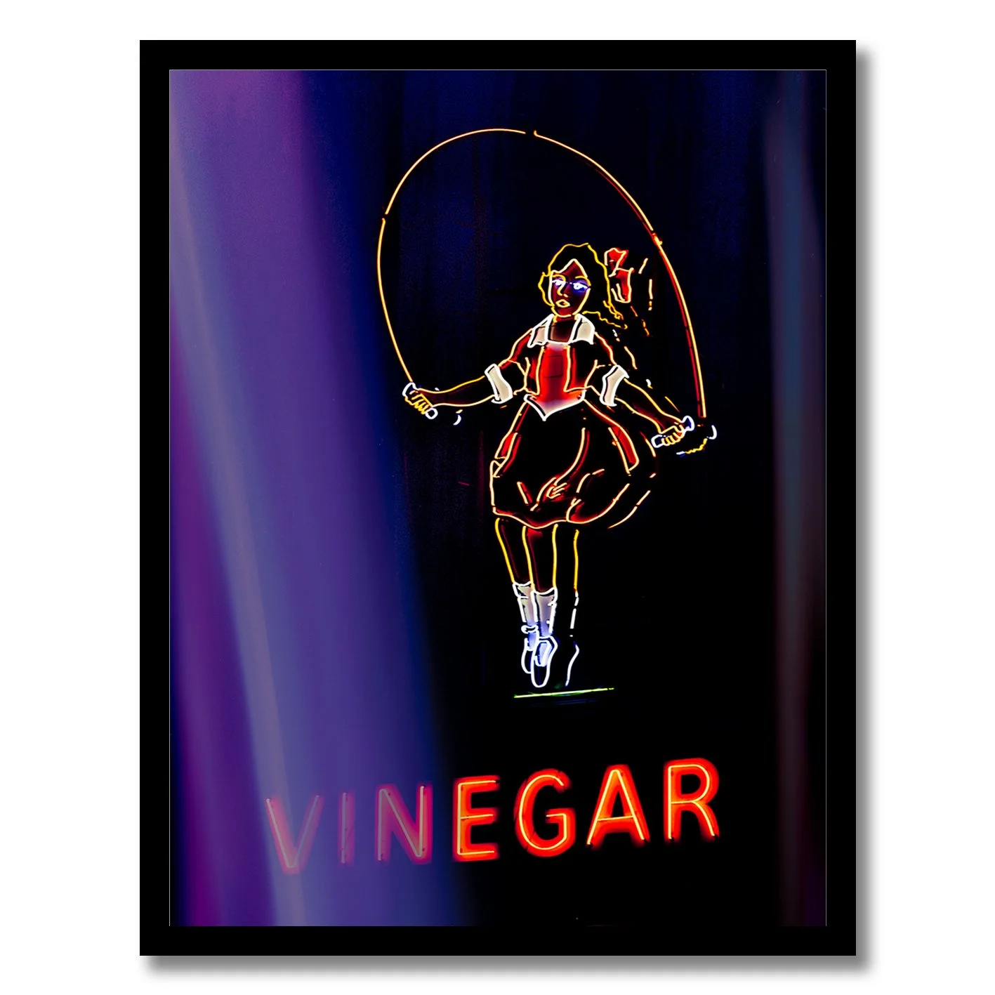 Neon photograph of Skipping Girl sign behind purple curtain light