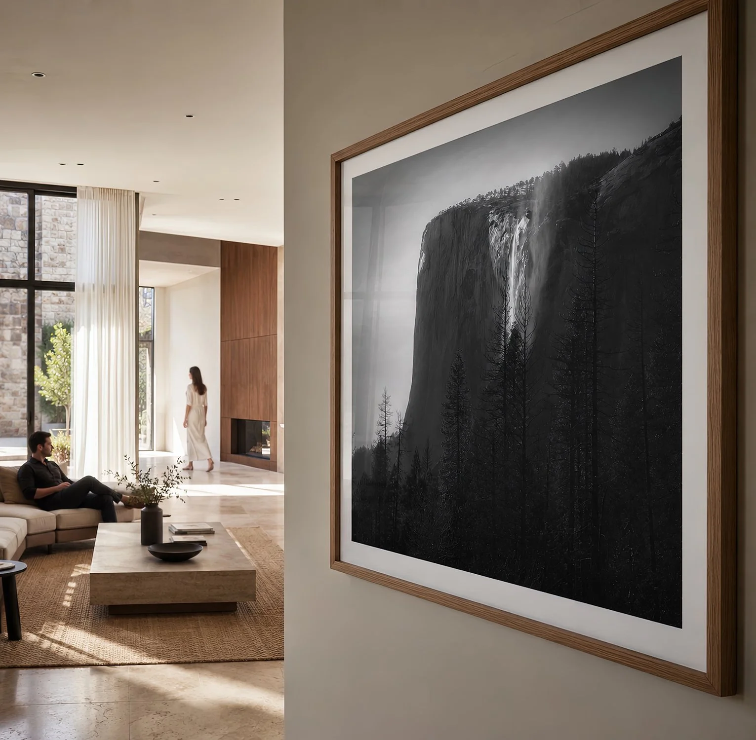 Close-up of a timber-framed monochrome Yosemite waterfall photograph in a sunlit living room with two people by Nick Psomiadis at NIKART Studio and Gallery