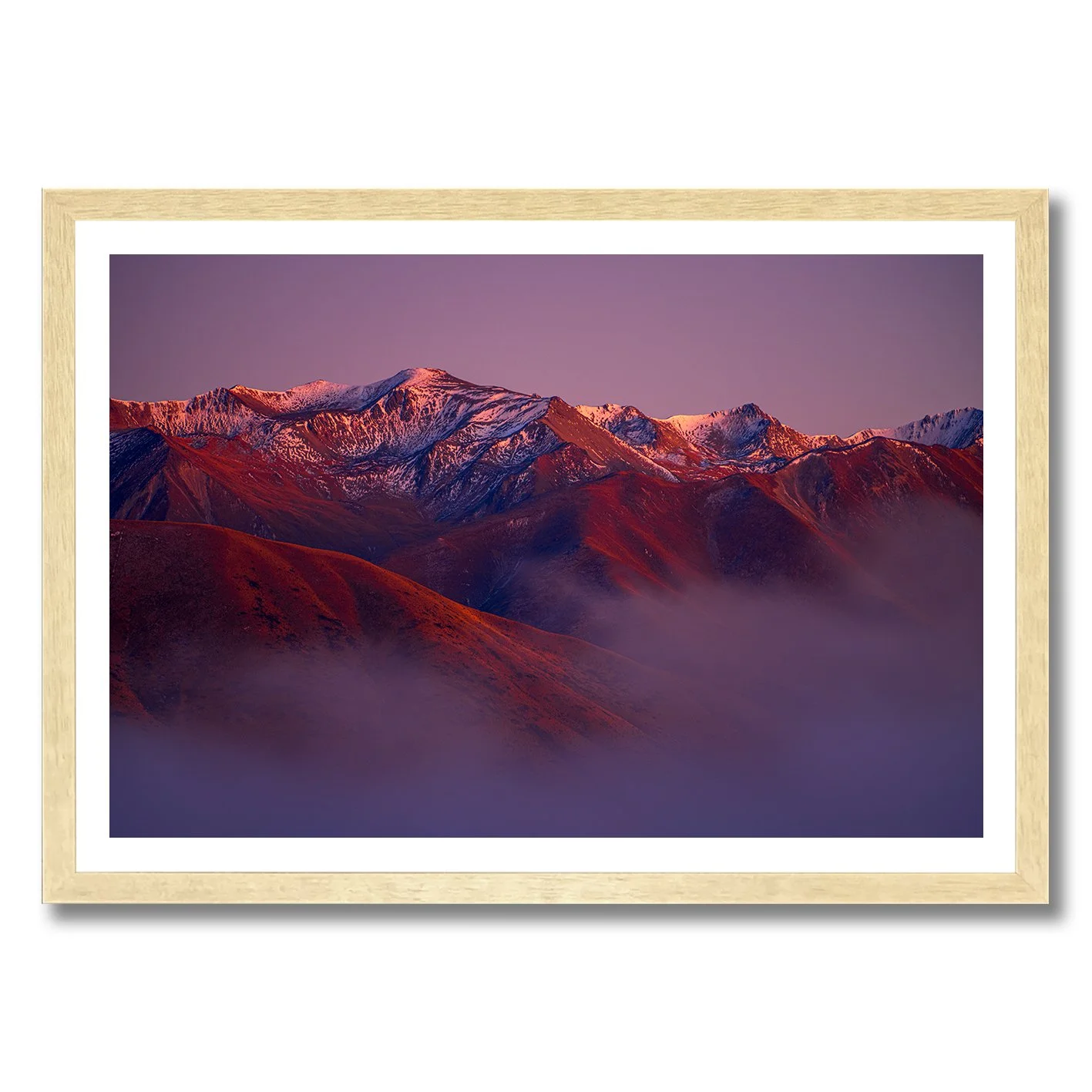 Mountain landscape photograph with alpenglow light on snowy peaks and misty valleys