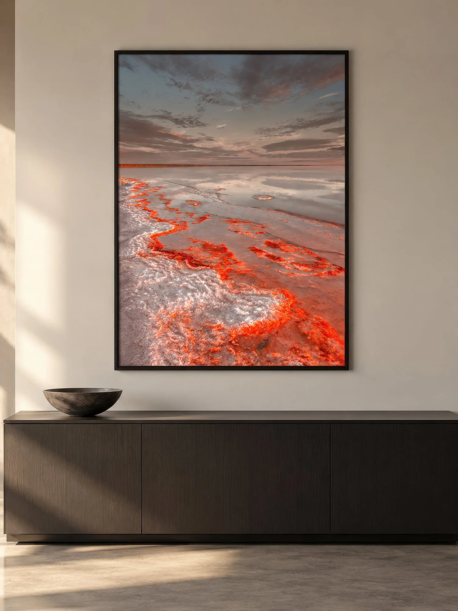 Lake Tyrrell photograph featuring vivid orange salt crystals in a black frame above a dark timber buffet in a minimalist interior by Nick Psomiadis at NIKART Studio and Gallery