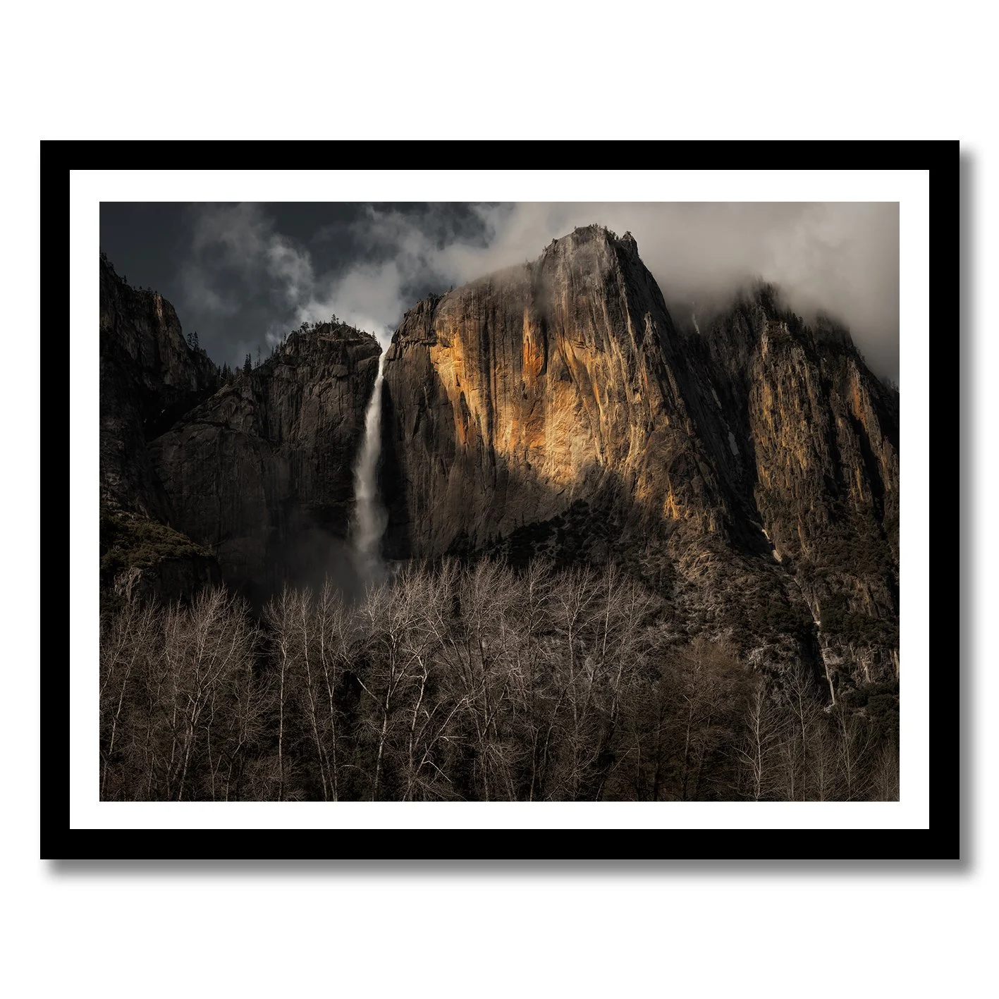 Yosemite Falls photograph with sunlit granite cliffs, mist and dark woodland in California