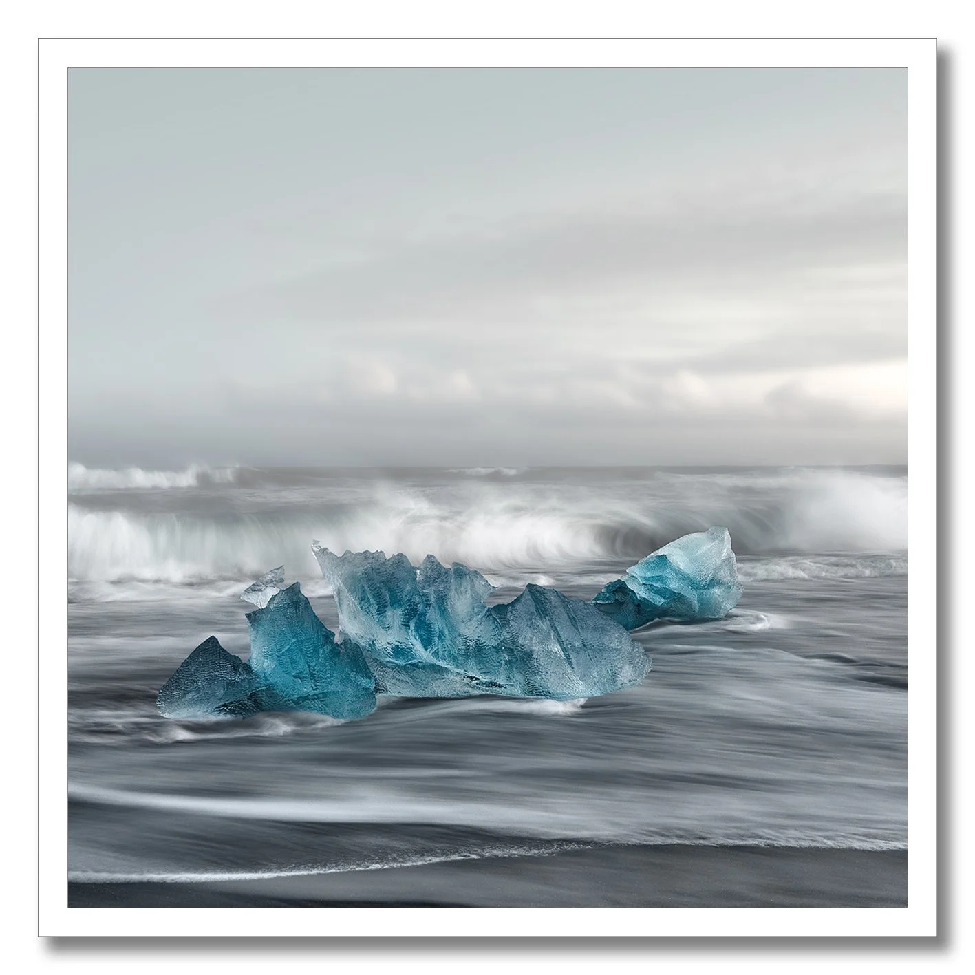 Fine art photograph of blue ice on Ice Beach with waves in Iceland